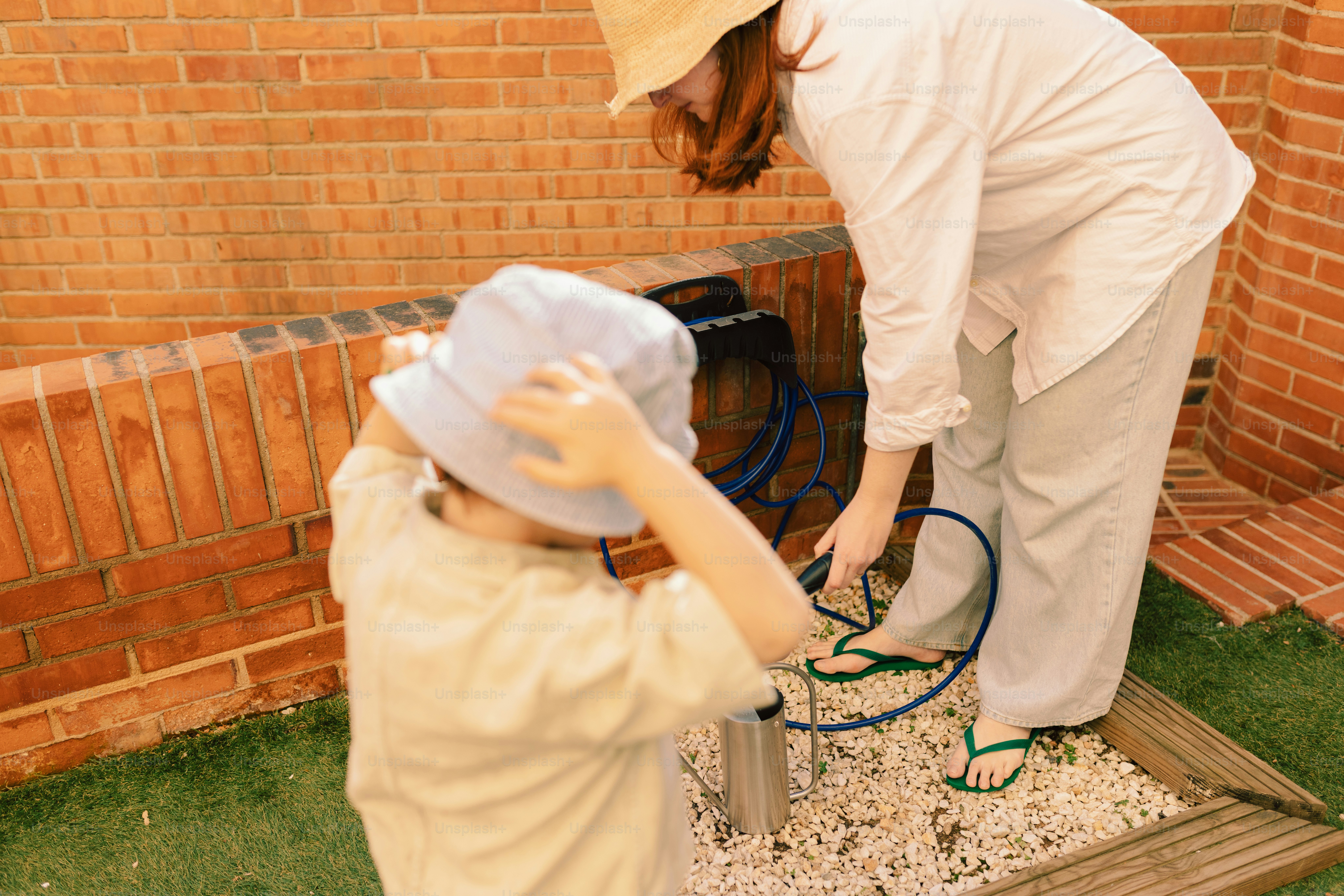 Donna e bambino che si prendono cura di un elemento del giardino