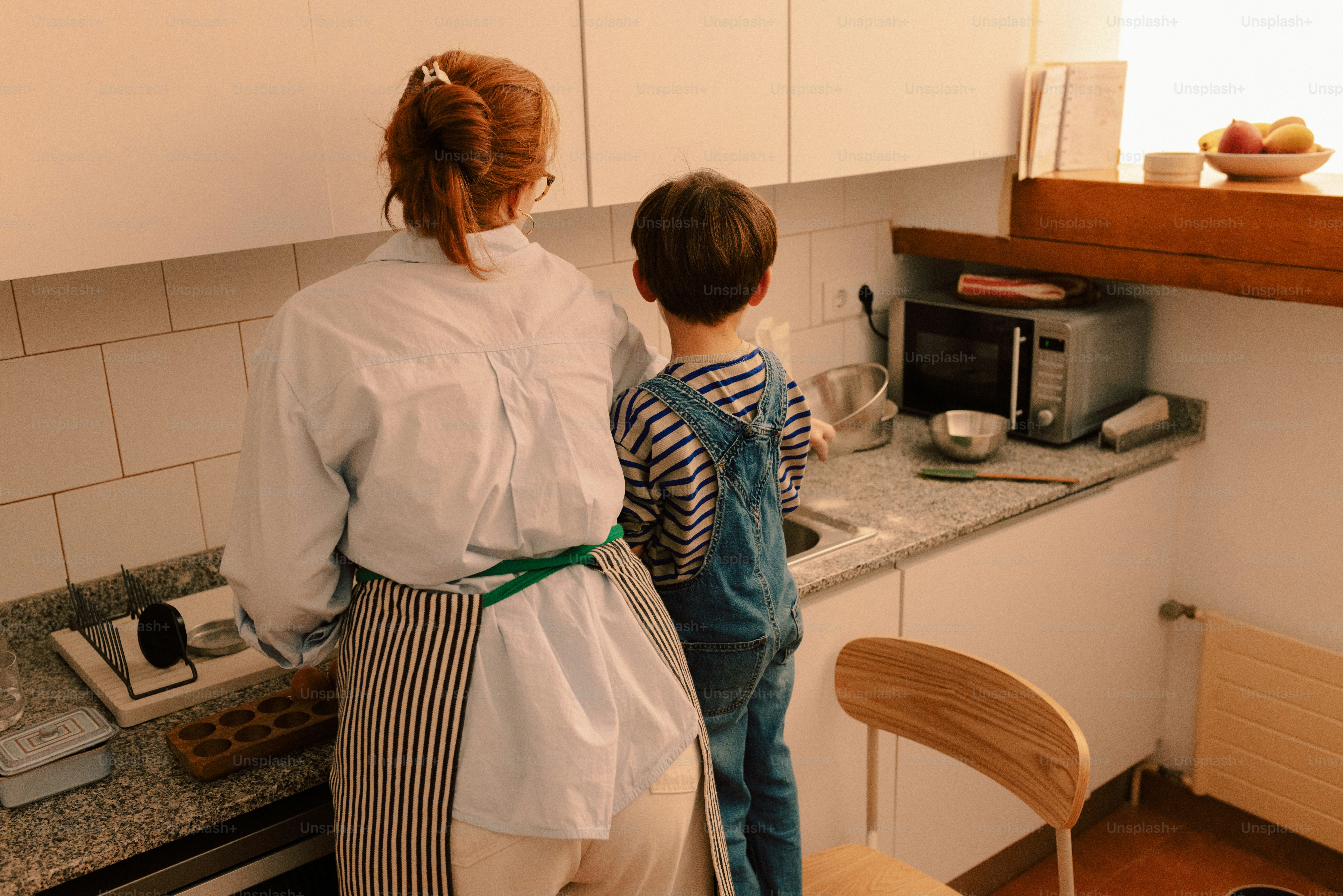 Woman and child baking in a kitchen.