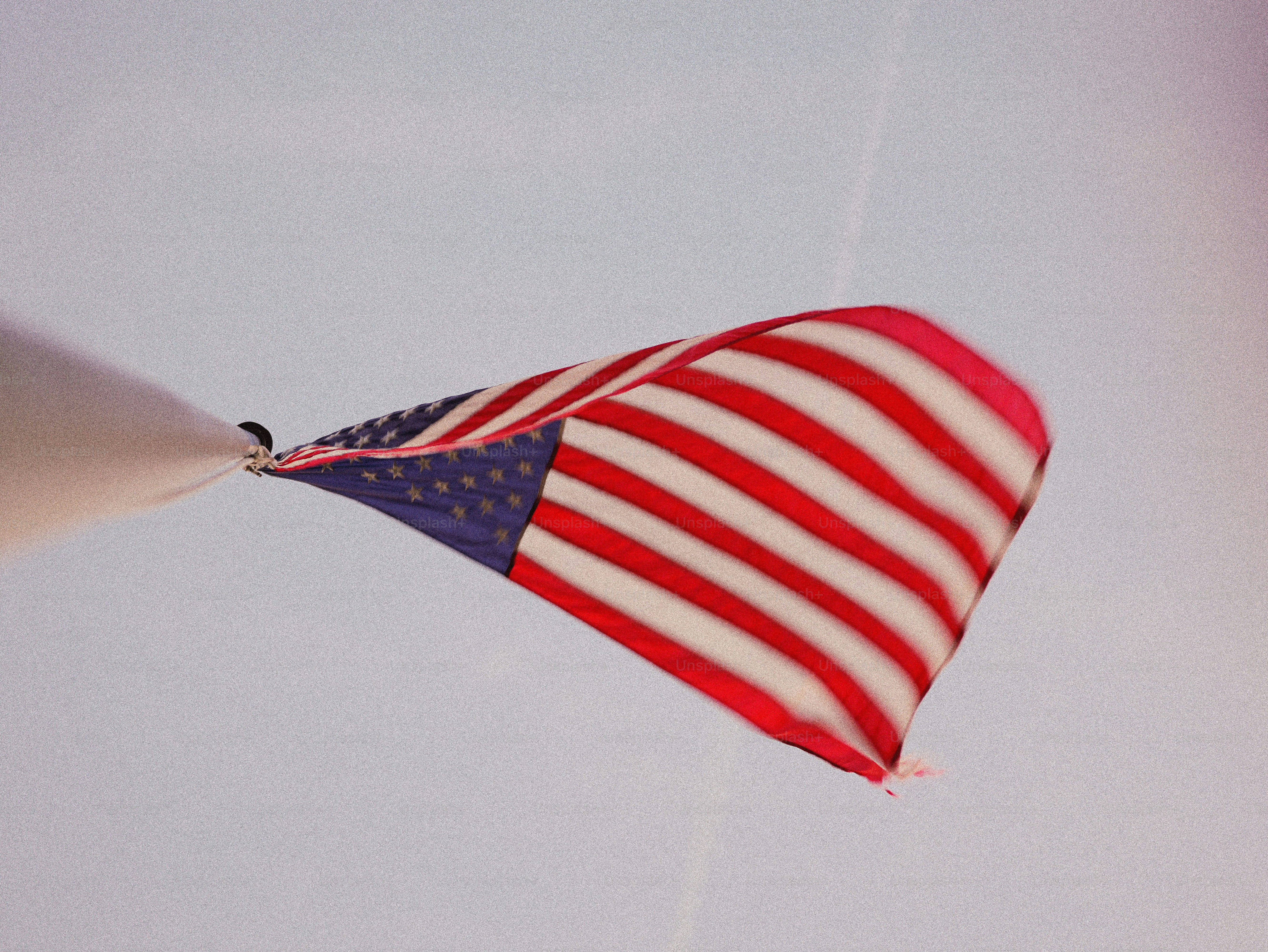 American flag waving against a light sky