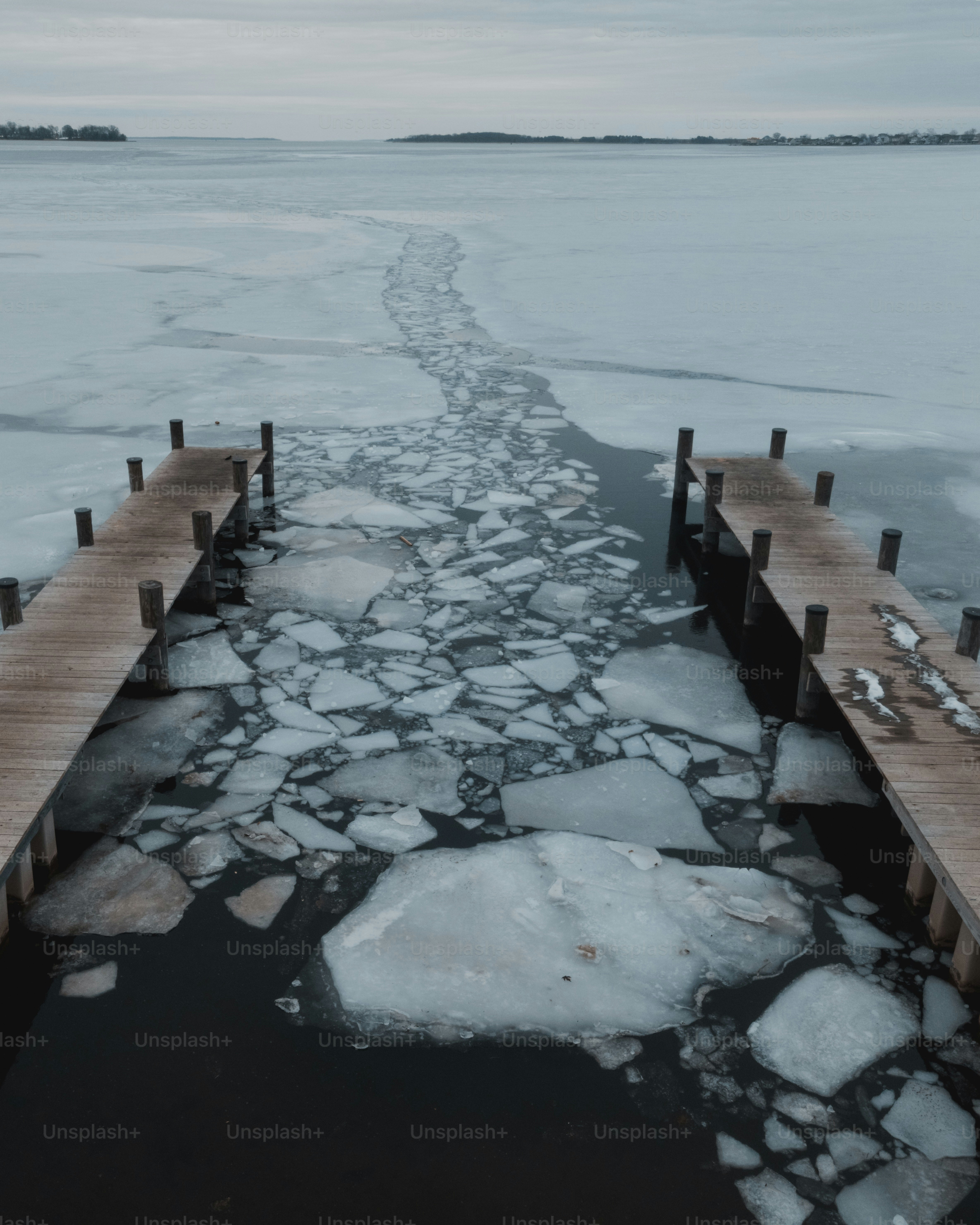 Wooden docks with ice breaking on a cold lake