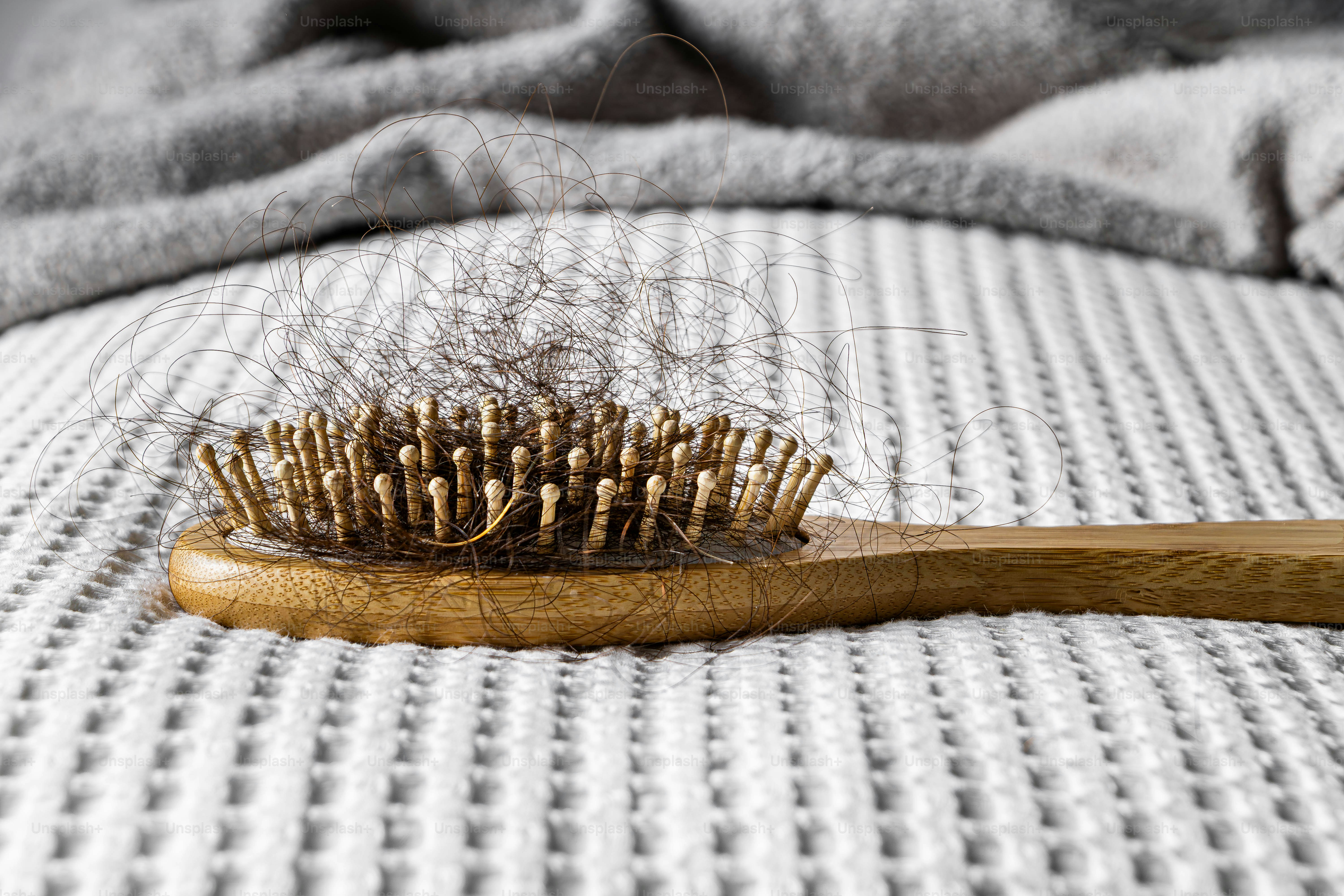 Haarbürste mit verfilztem Haar auf strukturierter Oberfläche