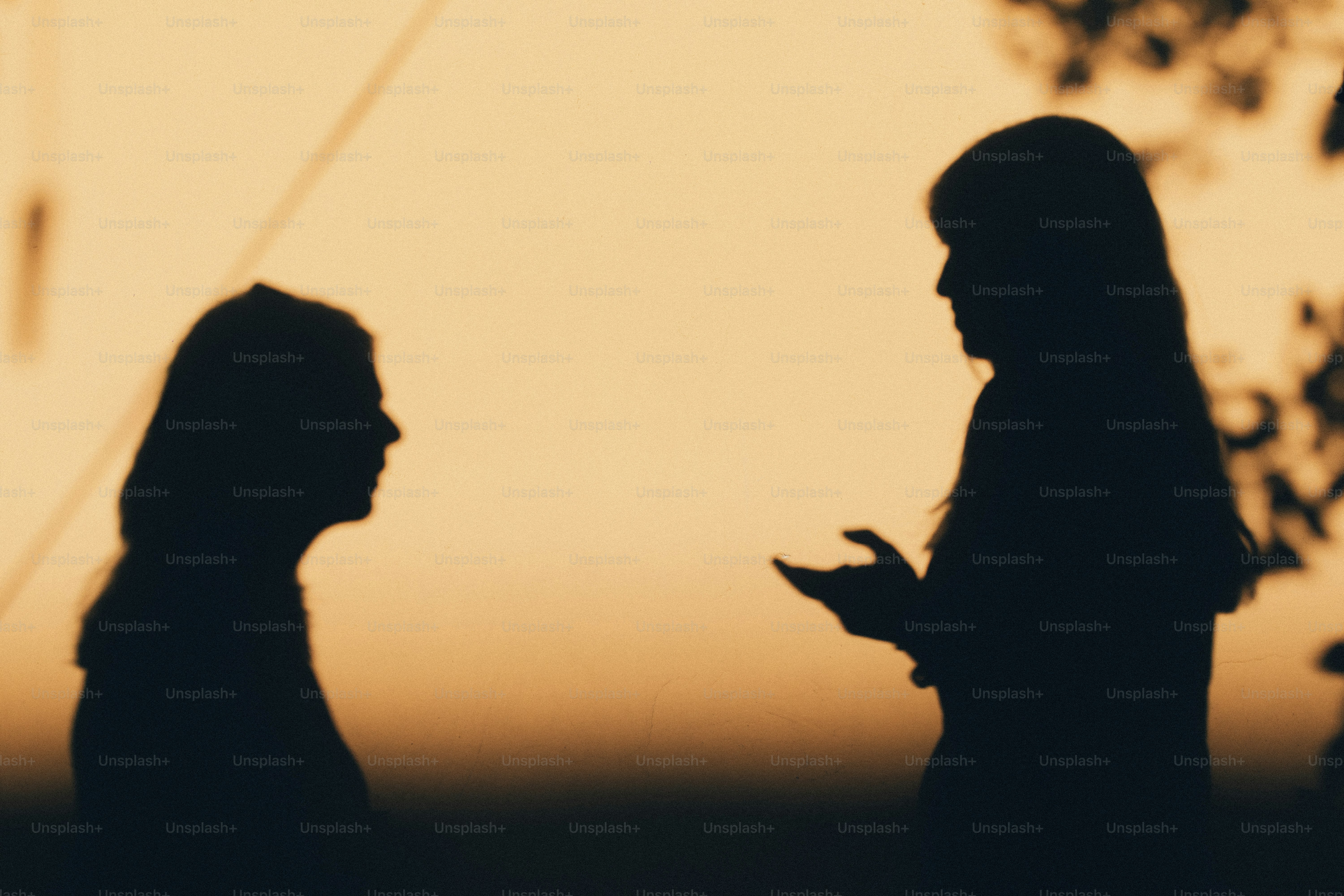 Due donne in controluce contro un cielo arancione