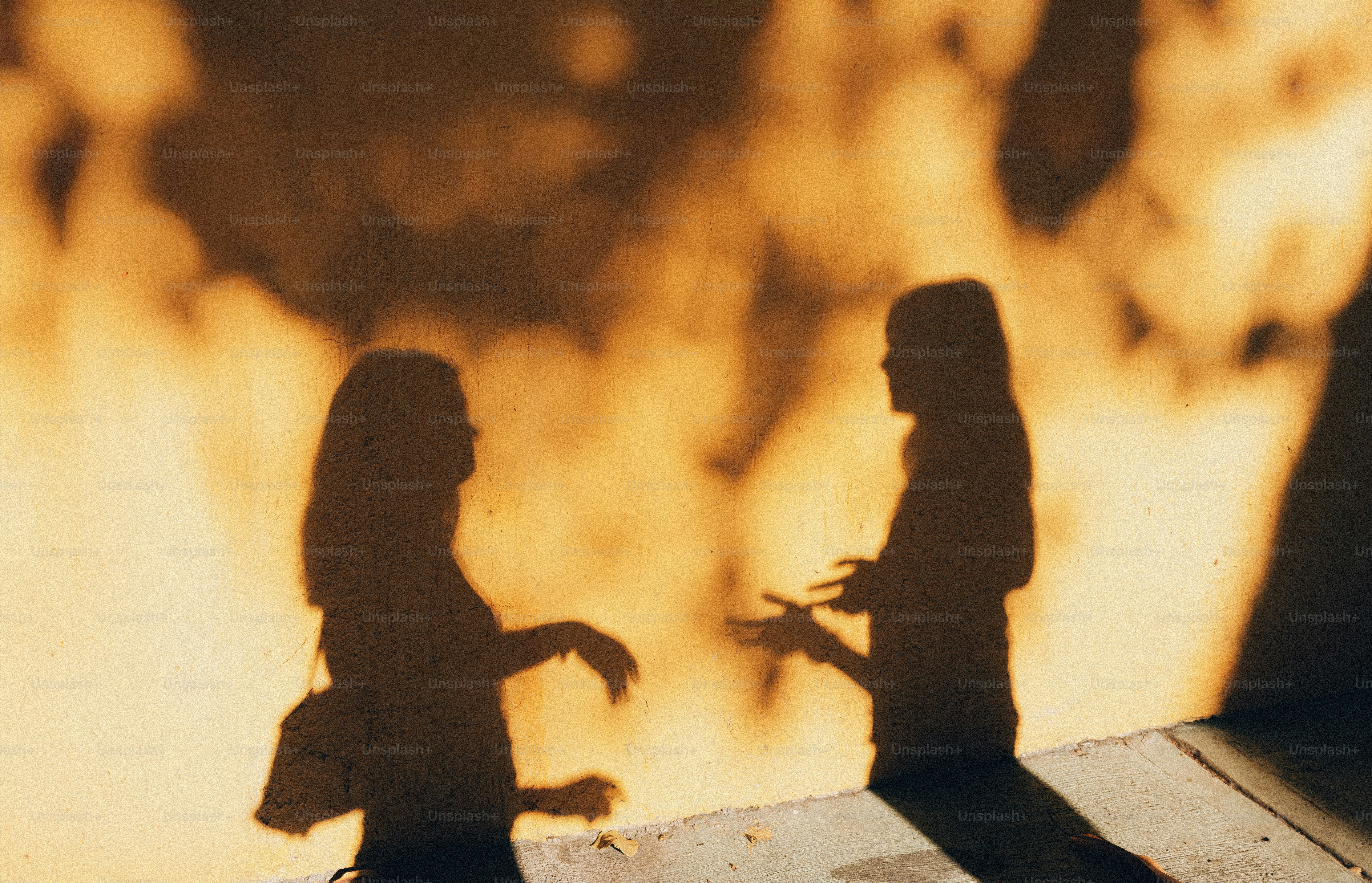 Shadows of two people talking on a wall photo – Portrait Image on Unsplash