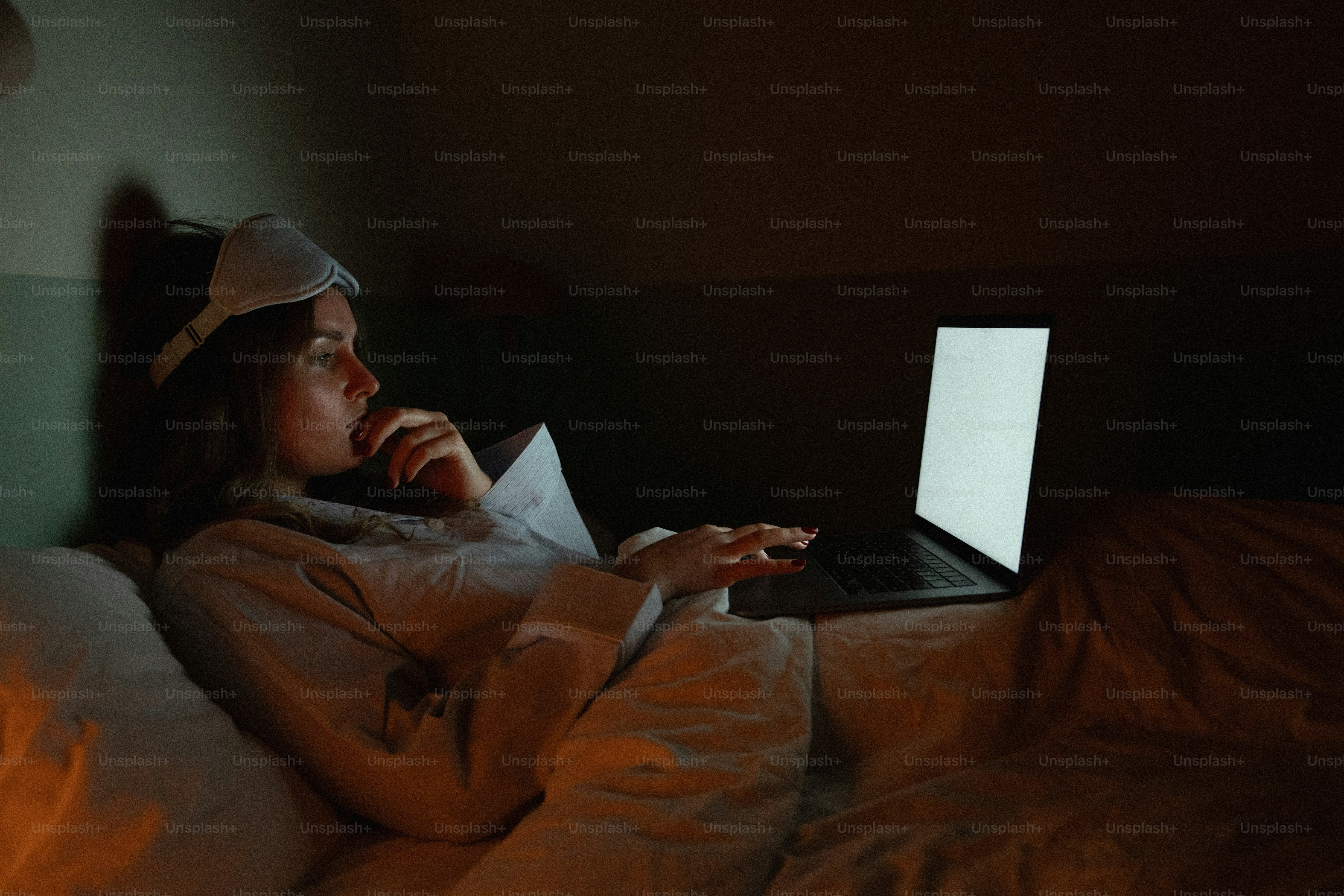 Mujer en la cama usando un portátil por la noche