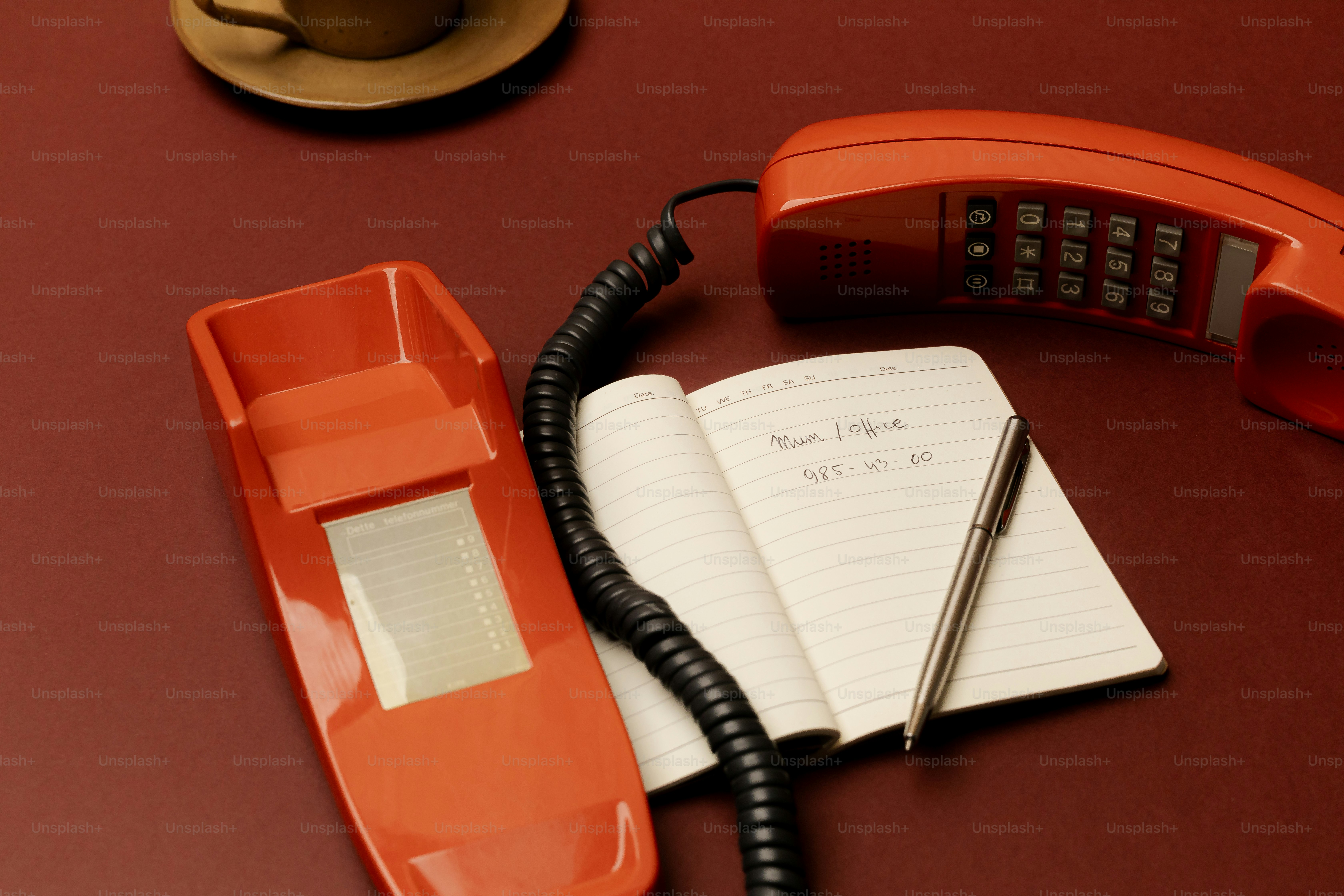 Retro orange telephone with notepad and pen