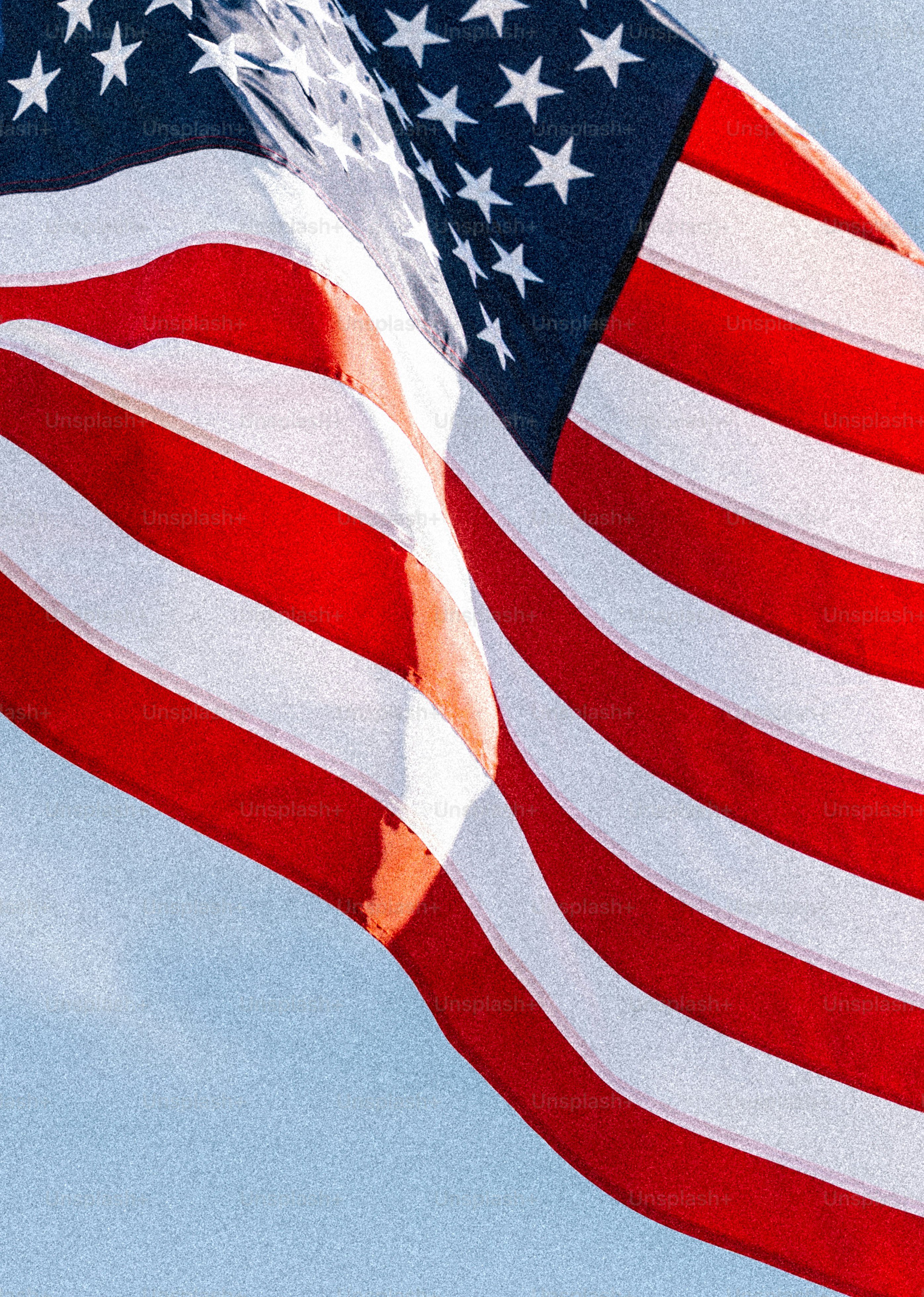 American flag waving against a clear blue sky