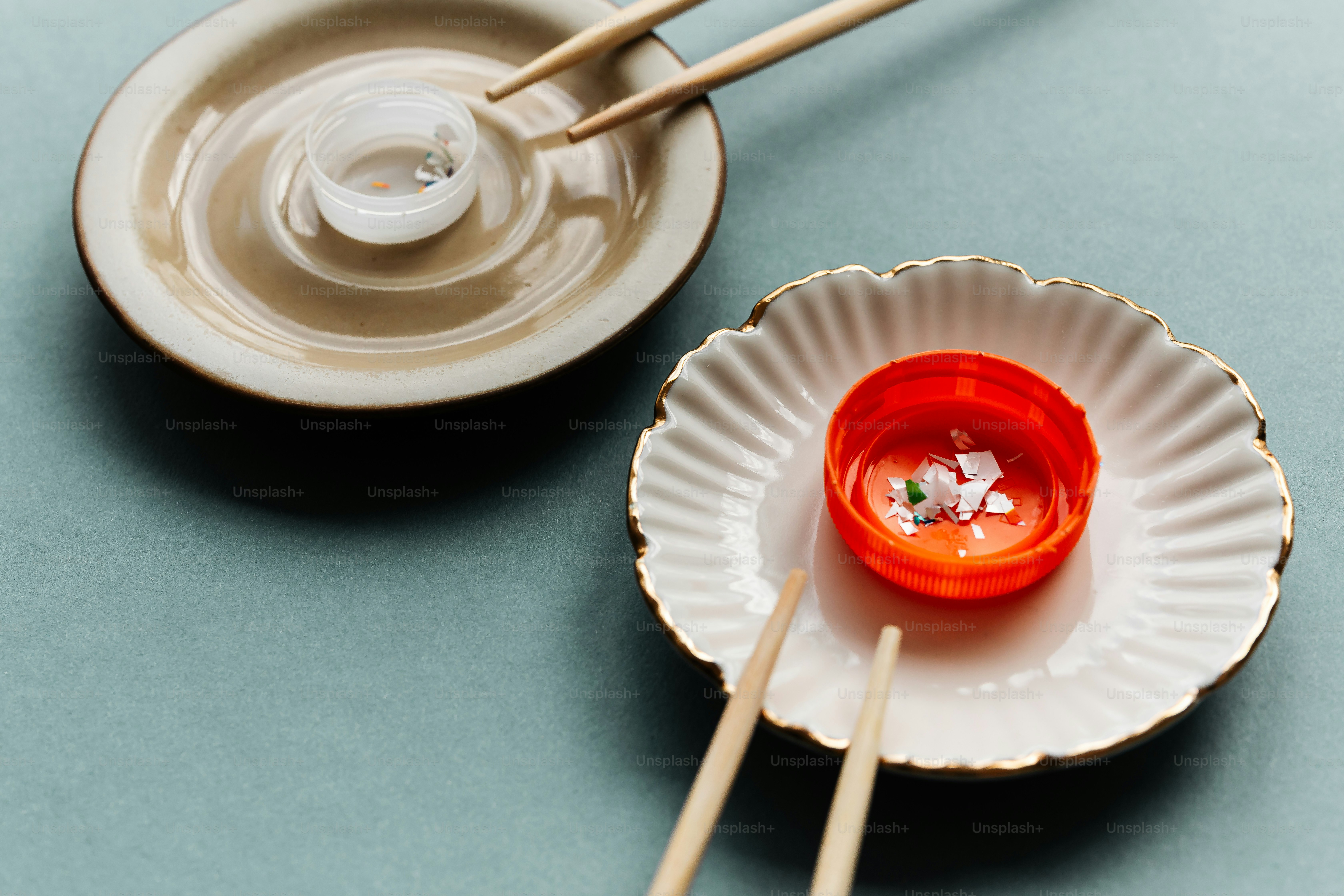 Chopsticks rest on small plates with sauce and garnish