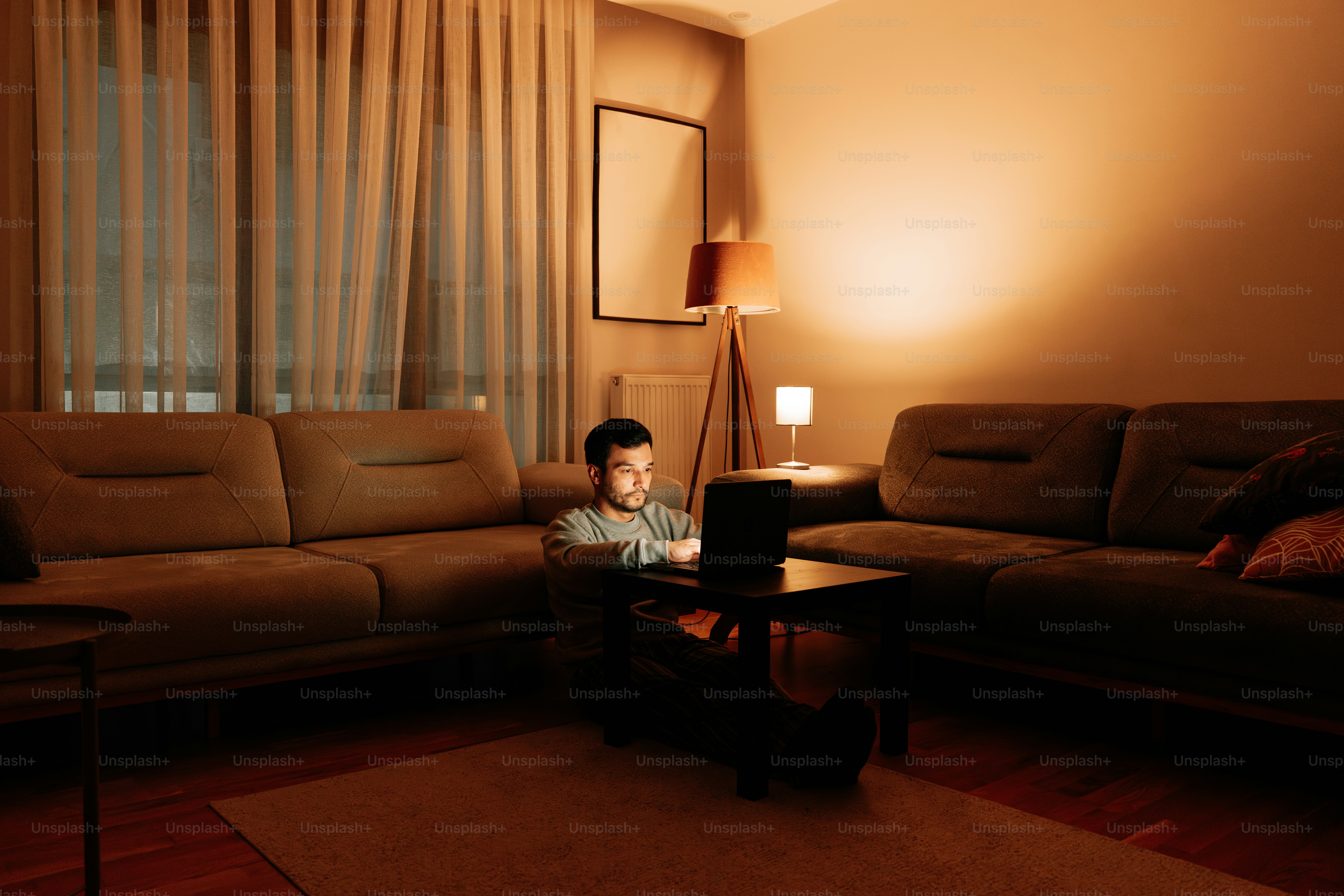 Young boy watches TV in dimly lit living room.
