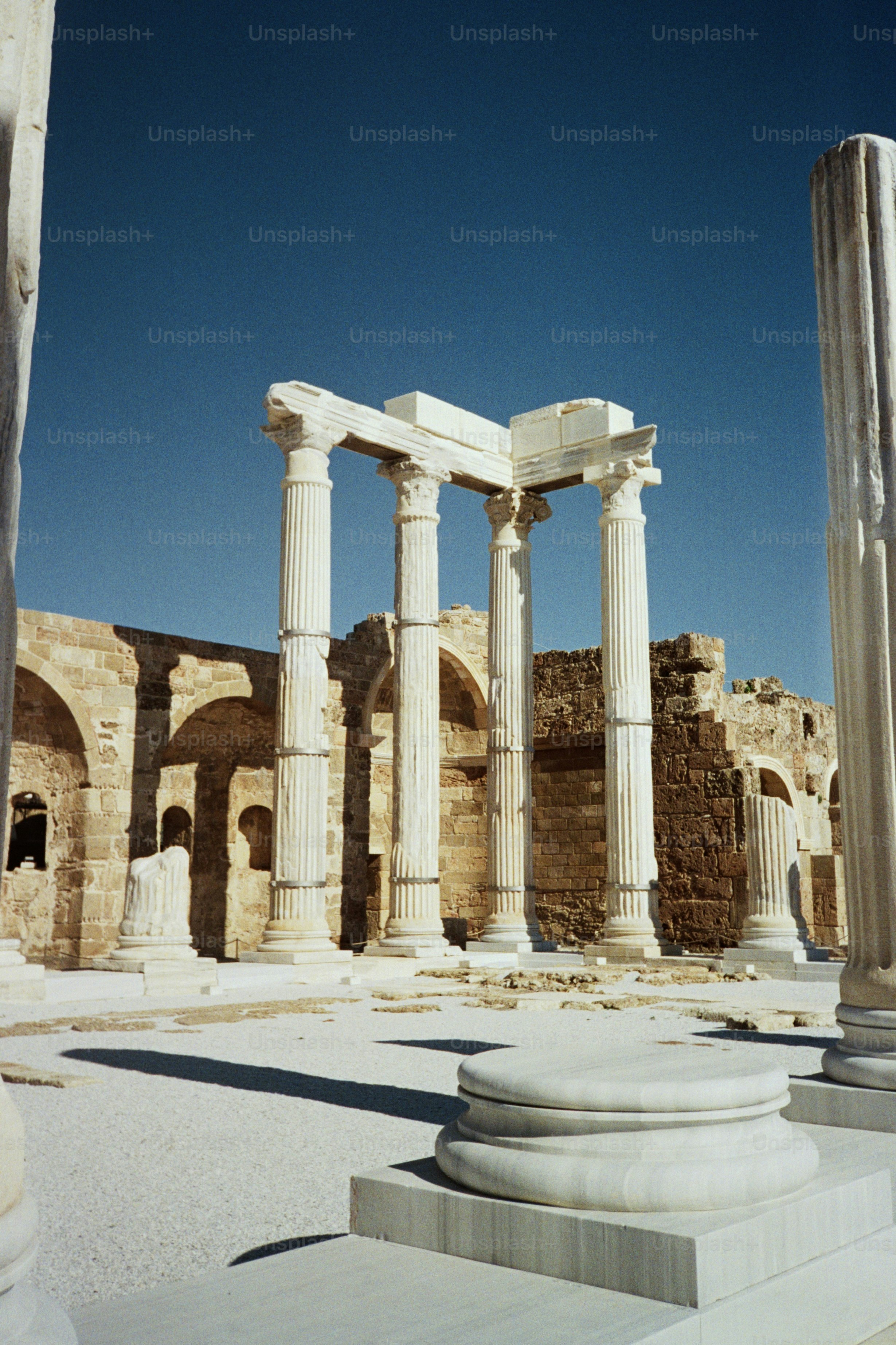 Ancient roman ruins with tall marble columns under blue sky photo ...