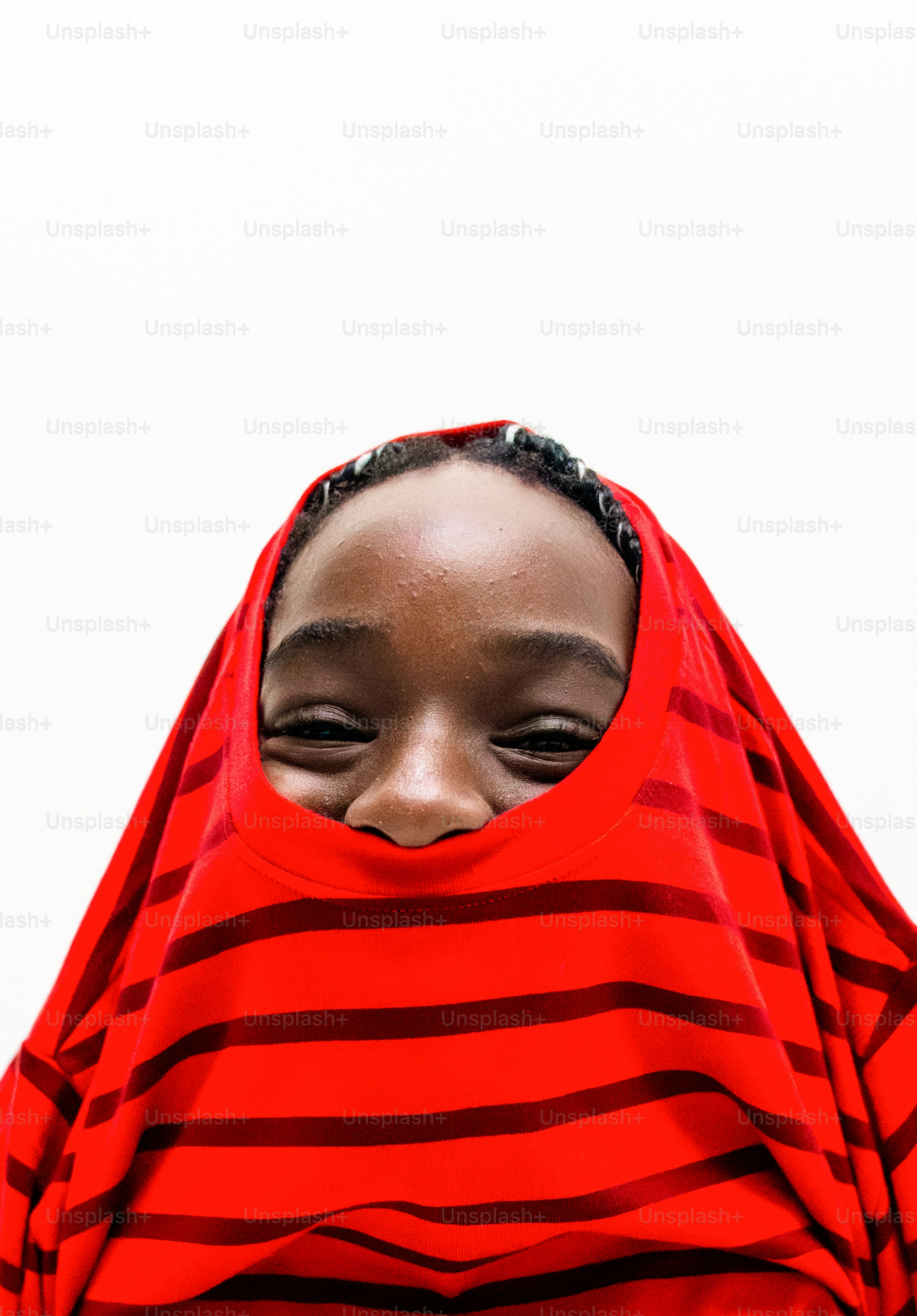 Un joven asomándose a través de una camiseta de rayas rojas