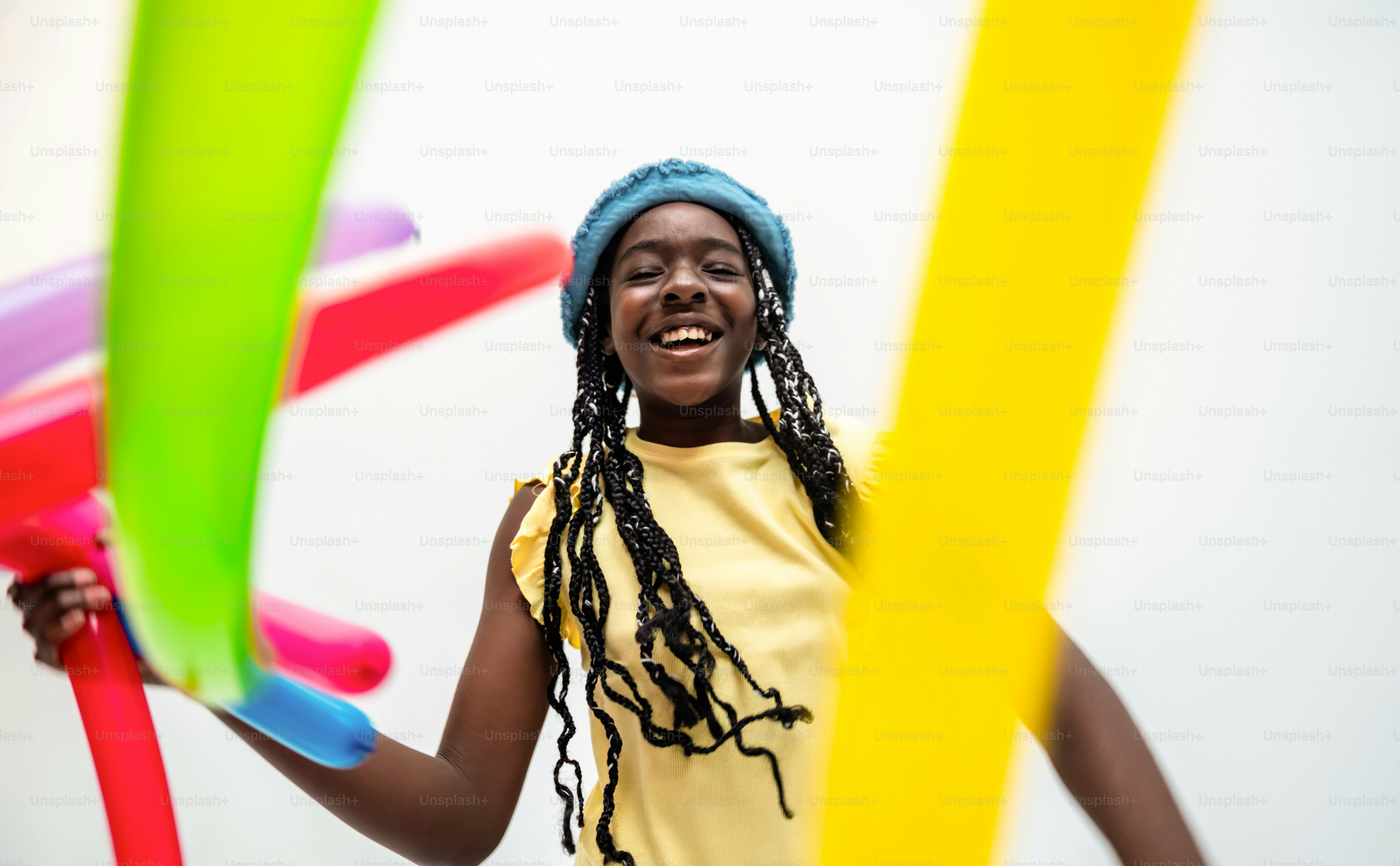 Joven negra riendo entre globos de colores