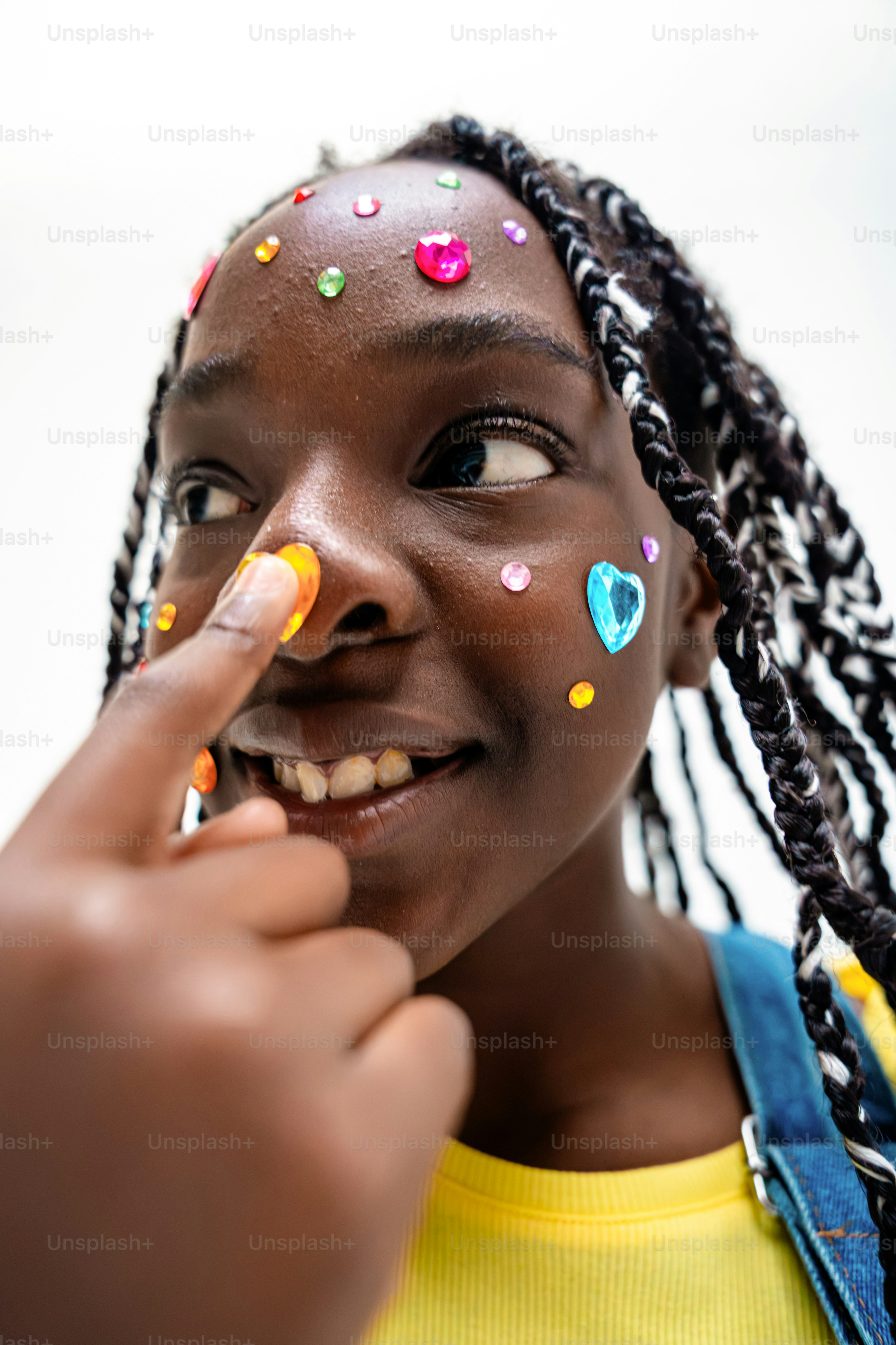 Una joven negra con gemas coloridas en la cara