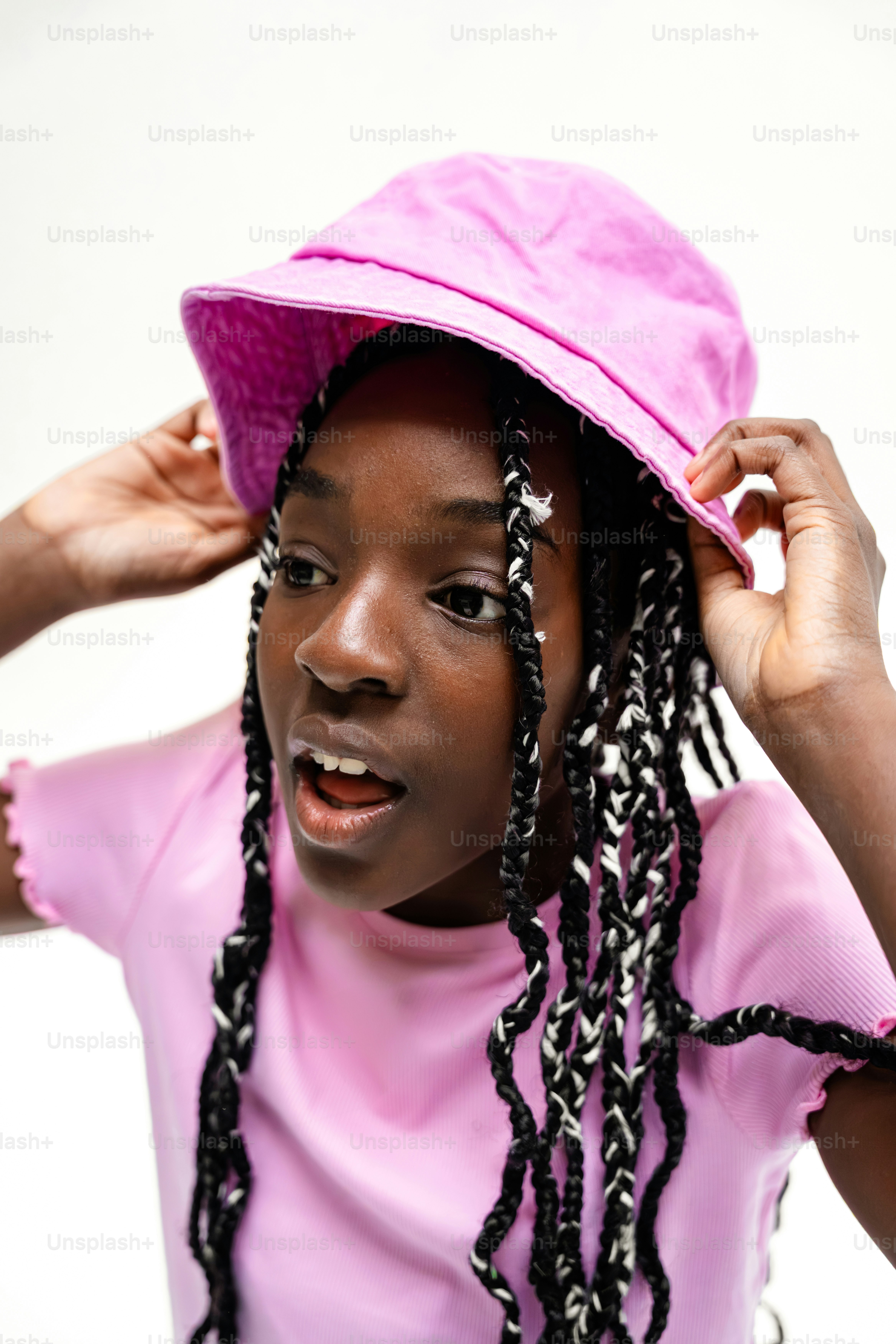 Una joven negra con un sombrero rosa tipo cubo