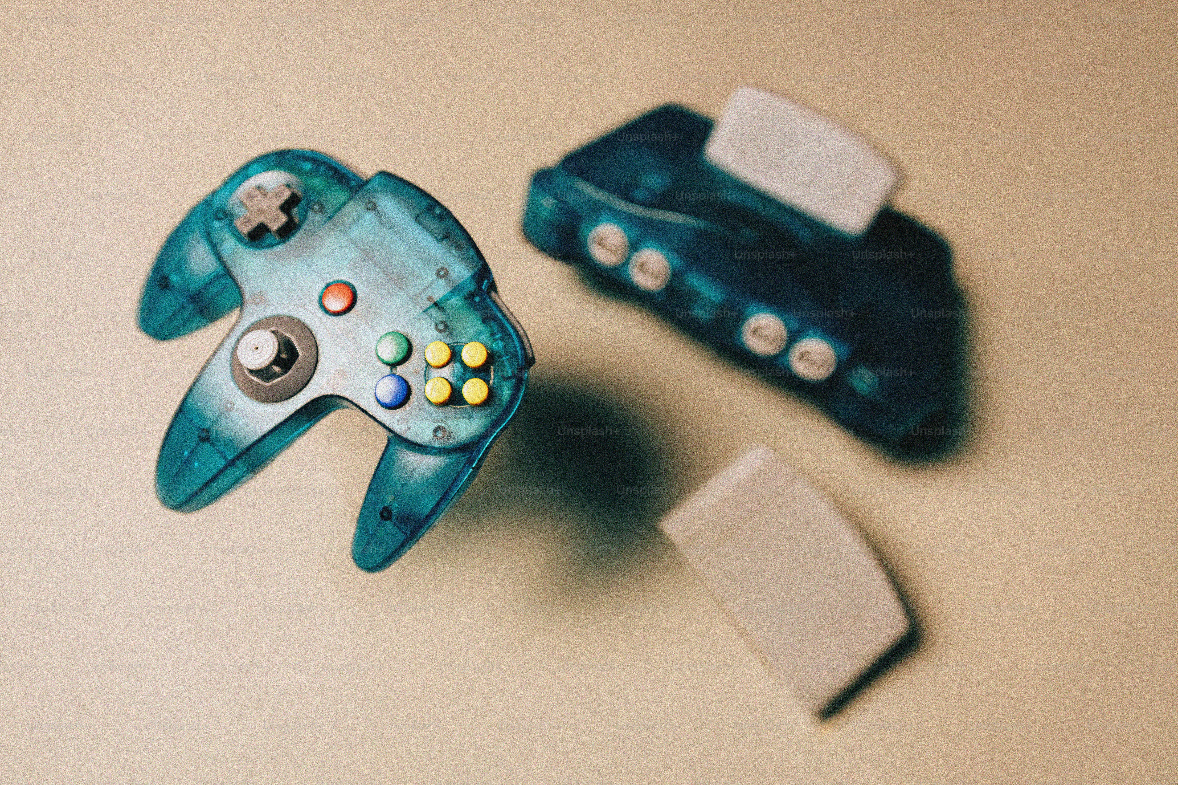 Two translucent blue nintendo 64 controllers and console photo ...
