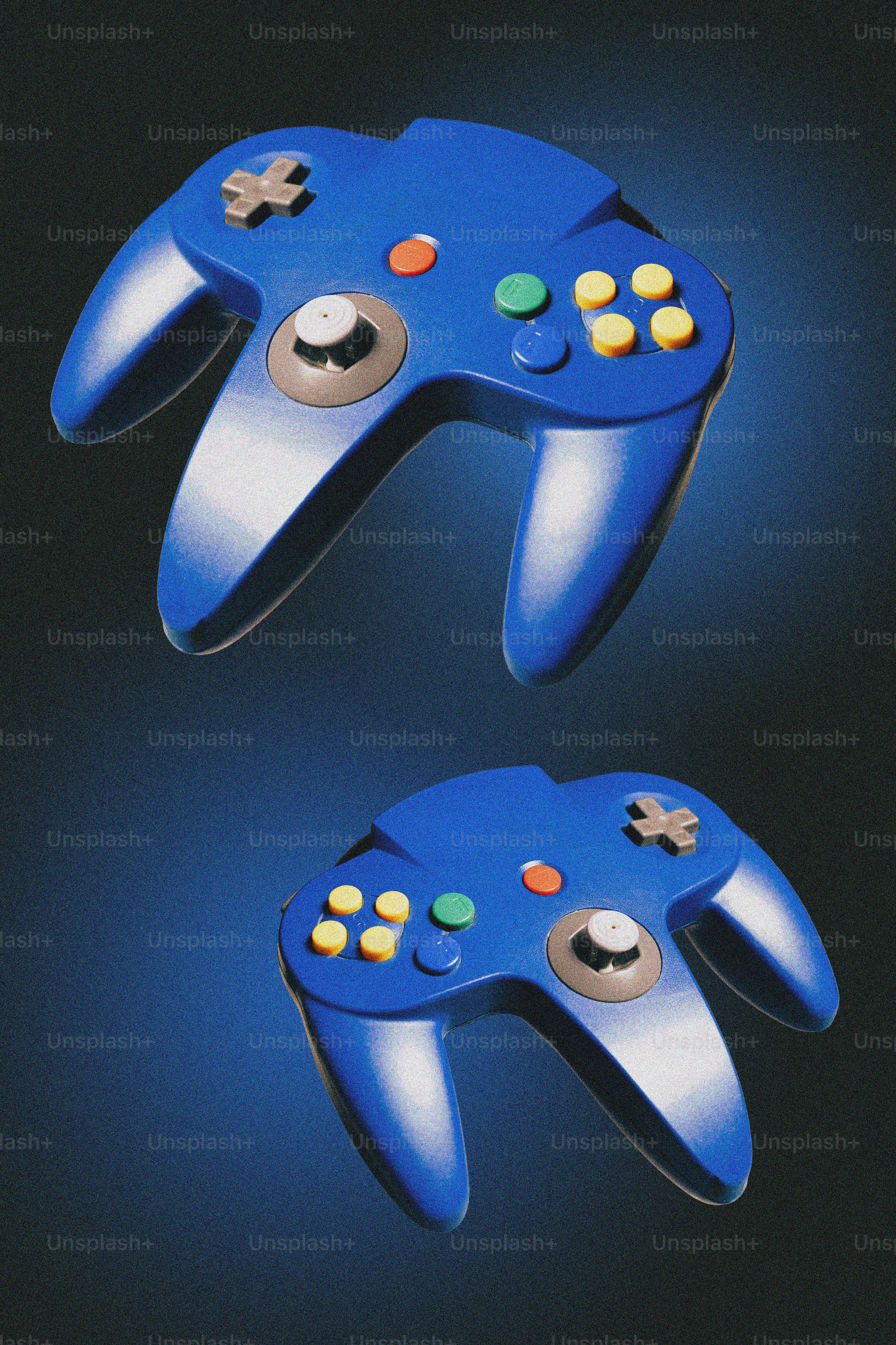 Two blue video game controllers on a dark background