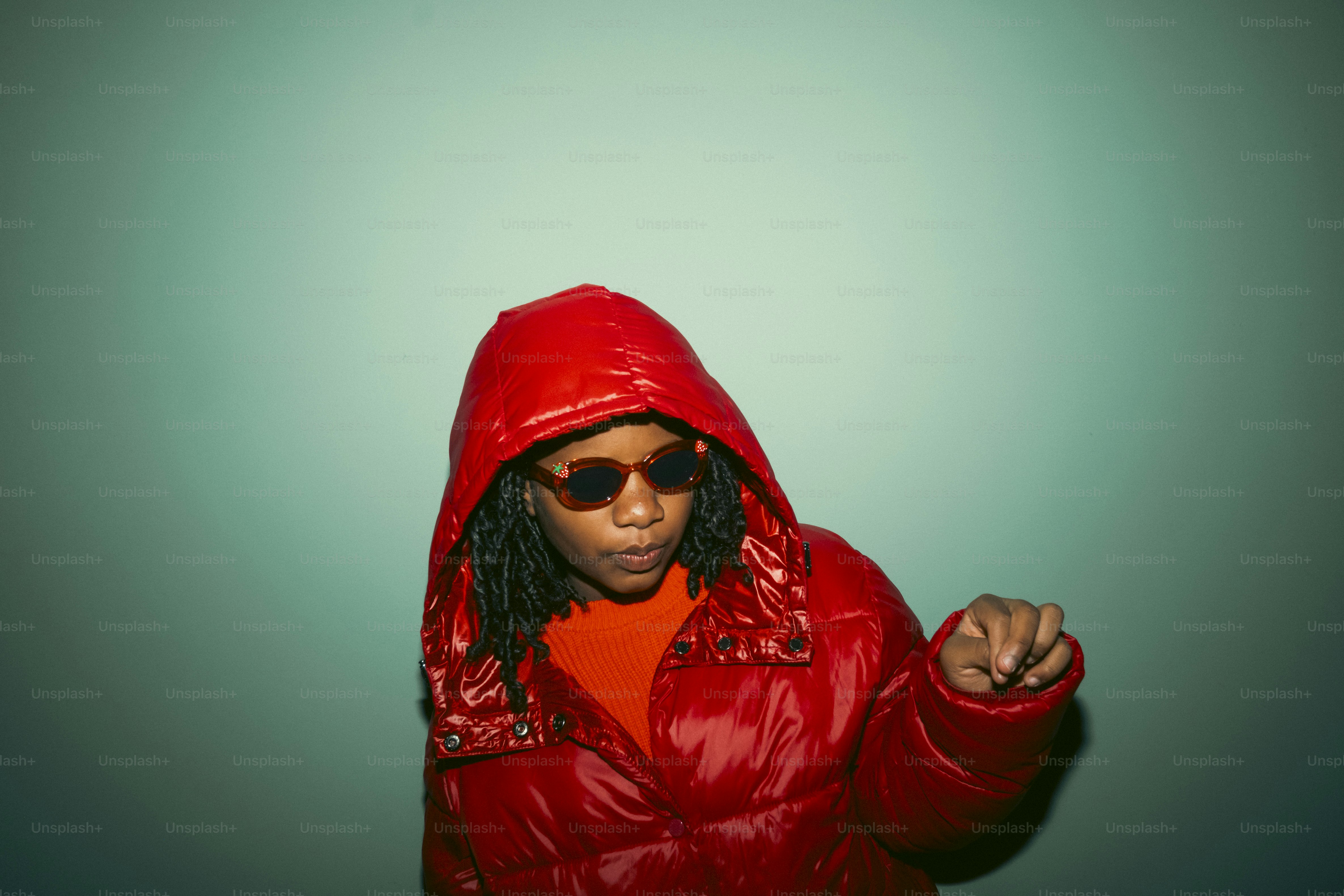 A person in a red puffer jacket and sunglasses.
