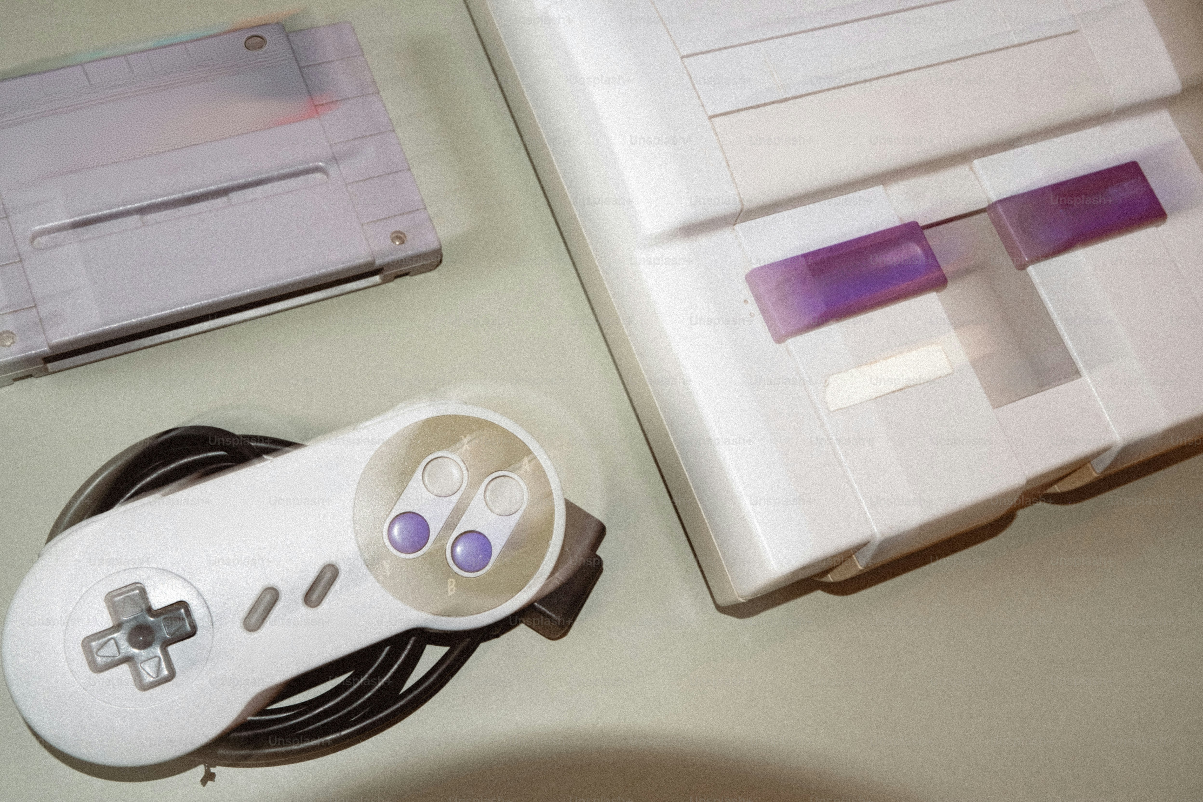 Consola de juegos retro blanca con mando y cartucho
