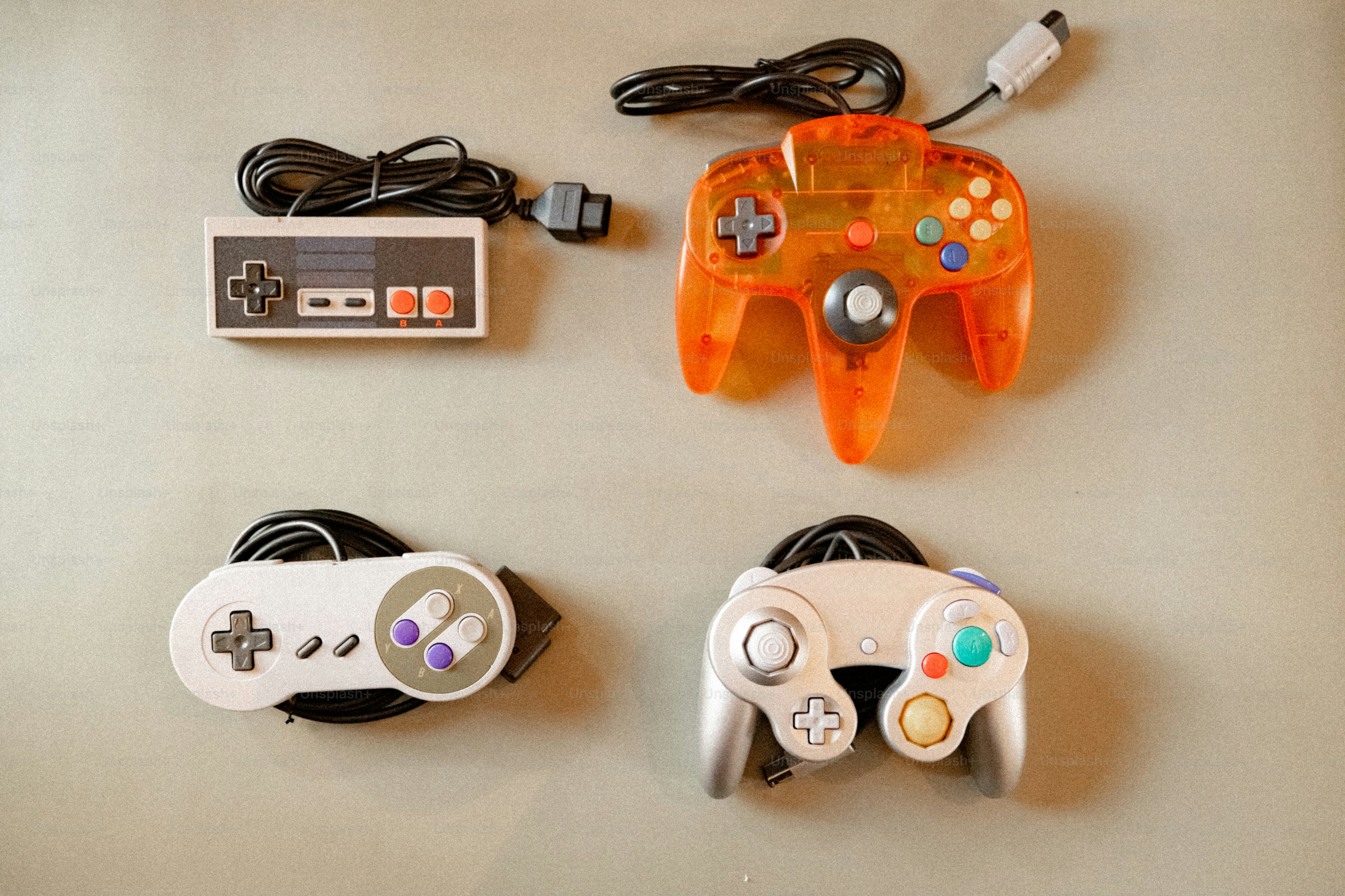 Four retro video game controllers on a surface photo – Technology Image ...