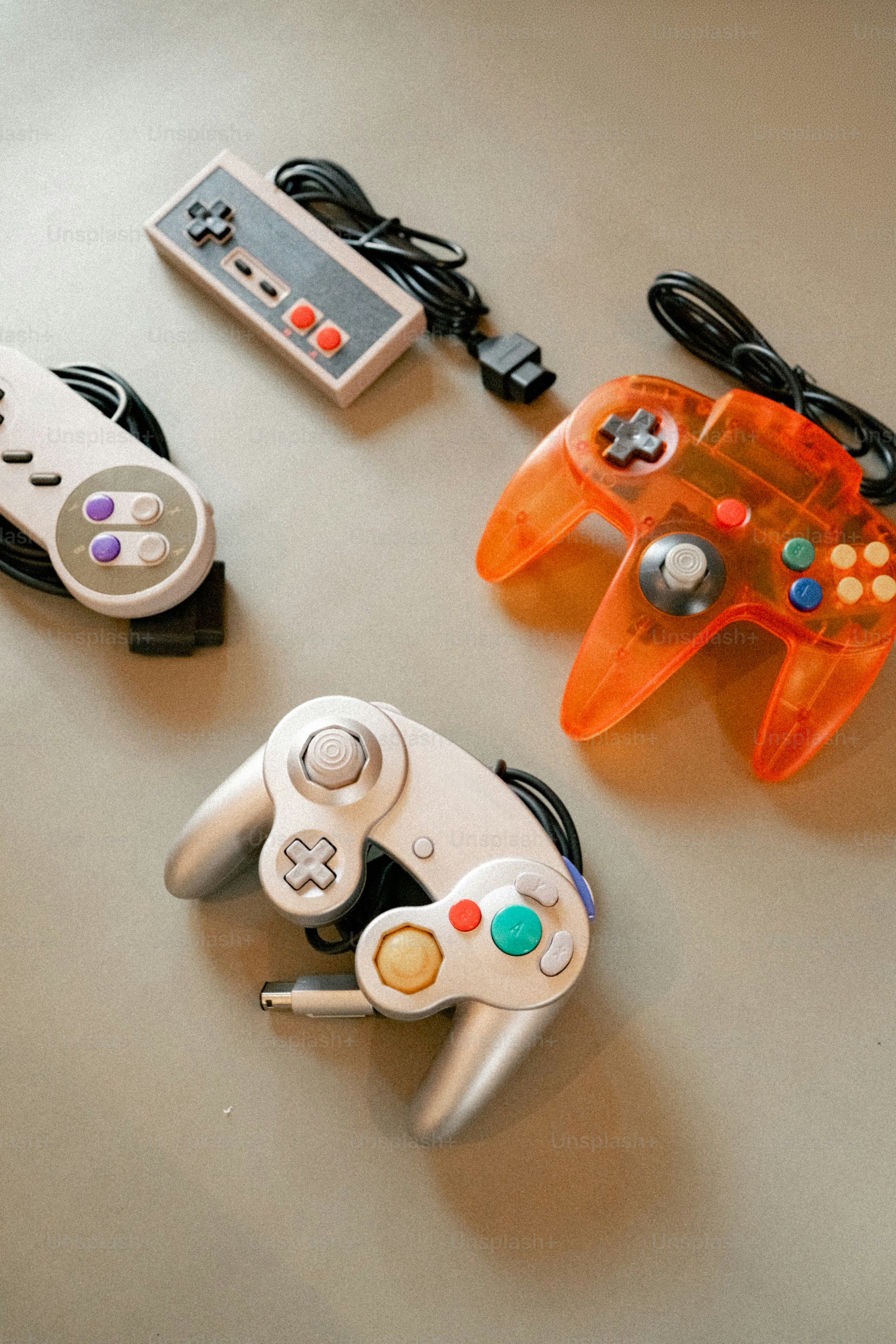 Four retro video game controllers on a surface photo – Technology Image ...