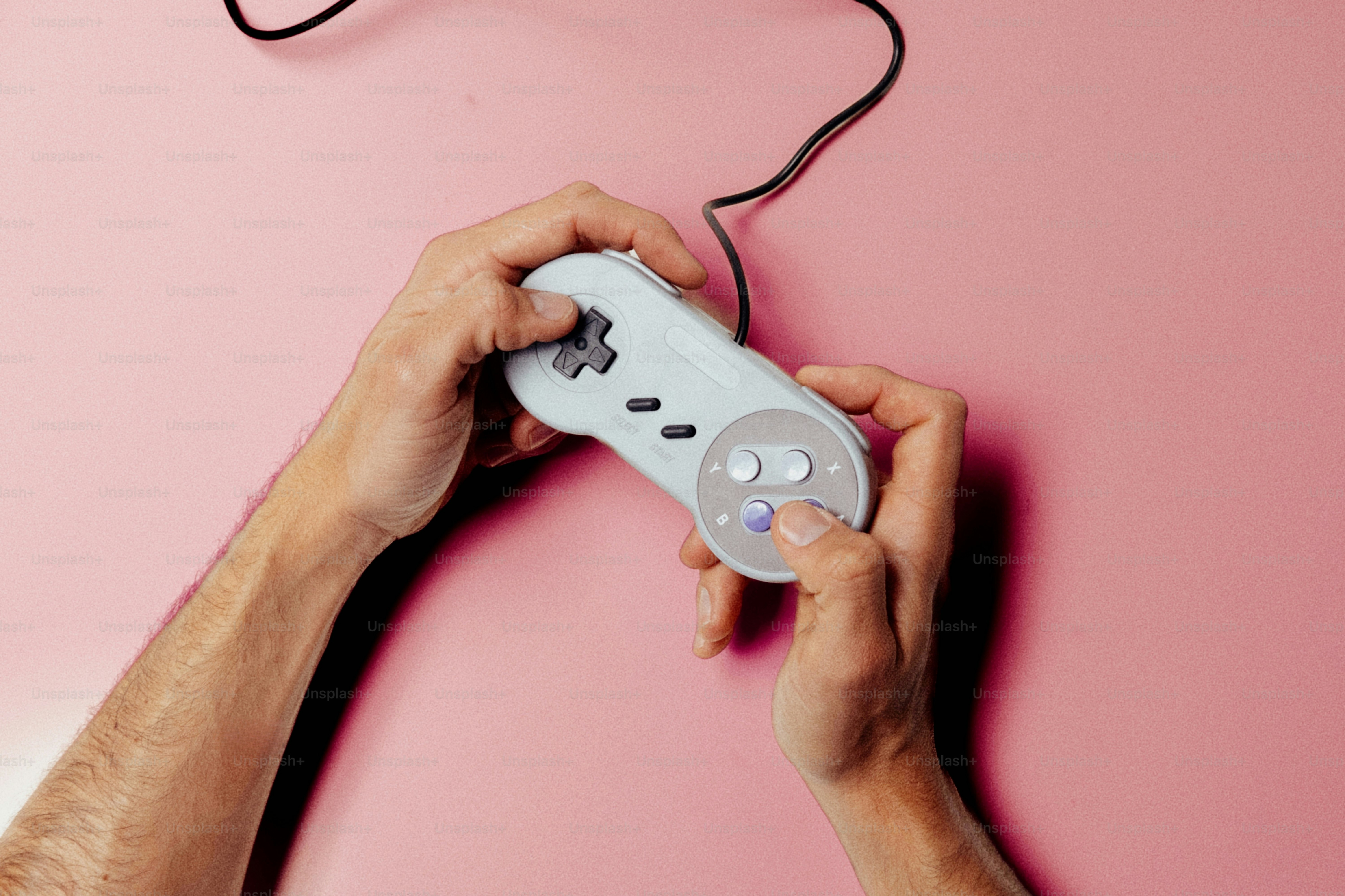 Tangan memegang pengontrol video game retro