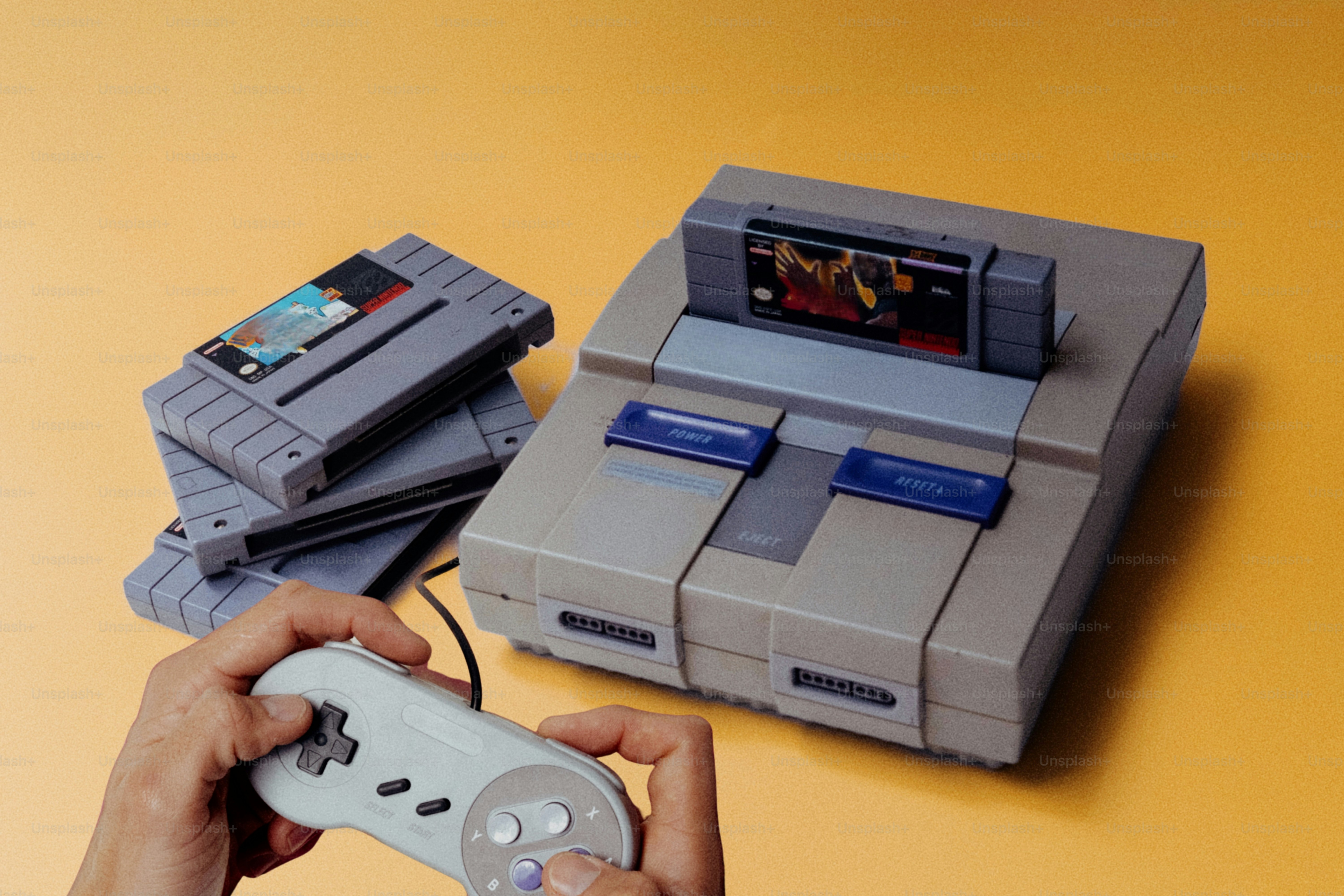 Hände, die einen Retro-Videospielcontroller in der Nähe der Konsole halten