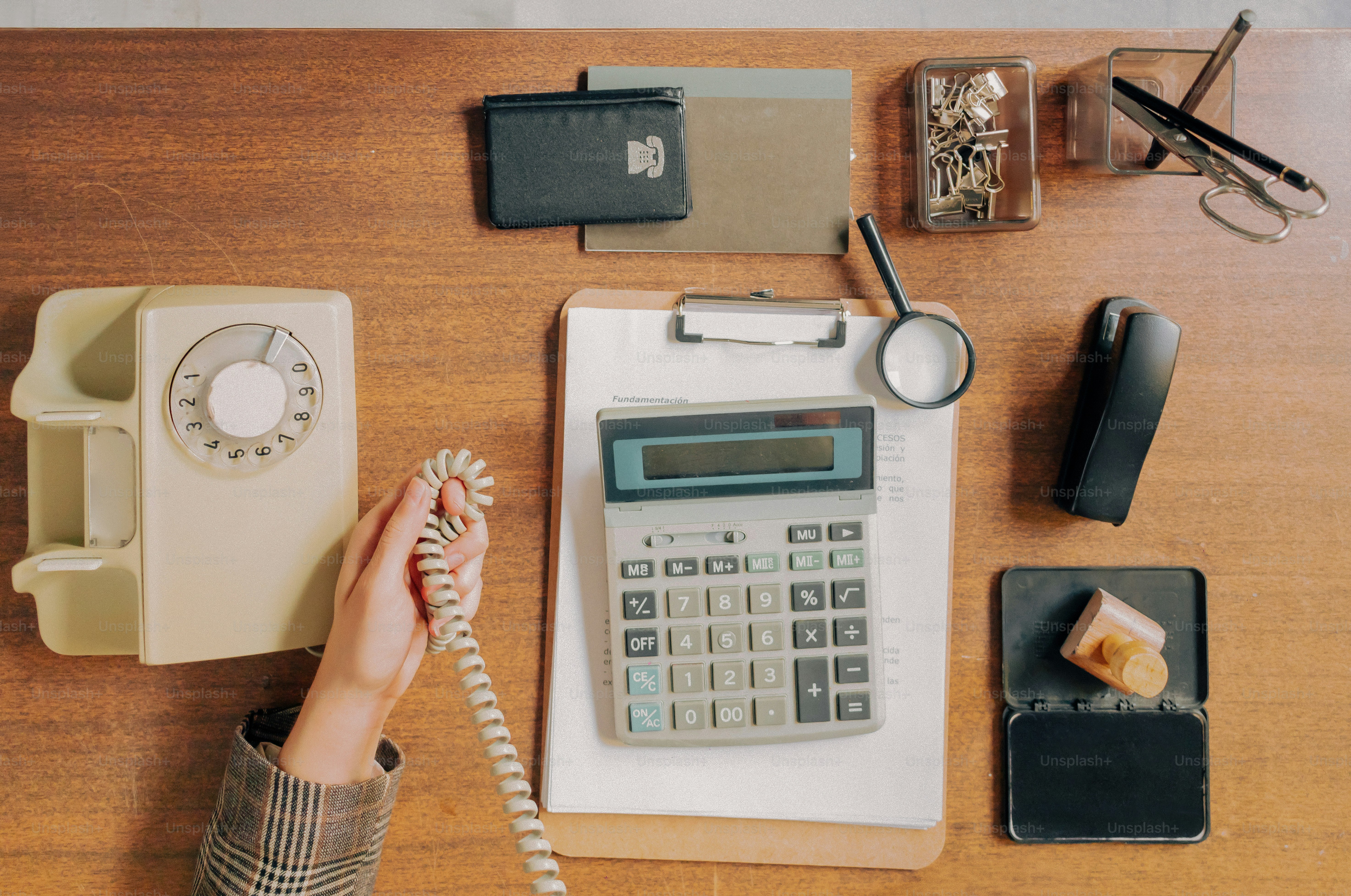 Meja dengan kalkulator vintage, telepon putar, dan perlengkapan kantor