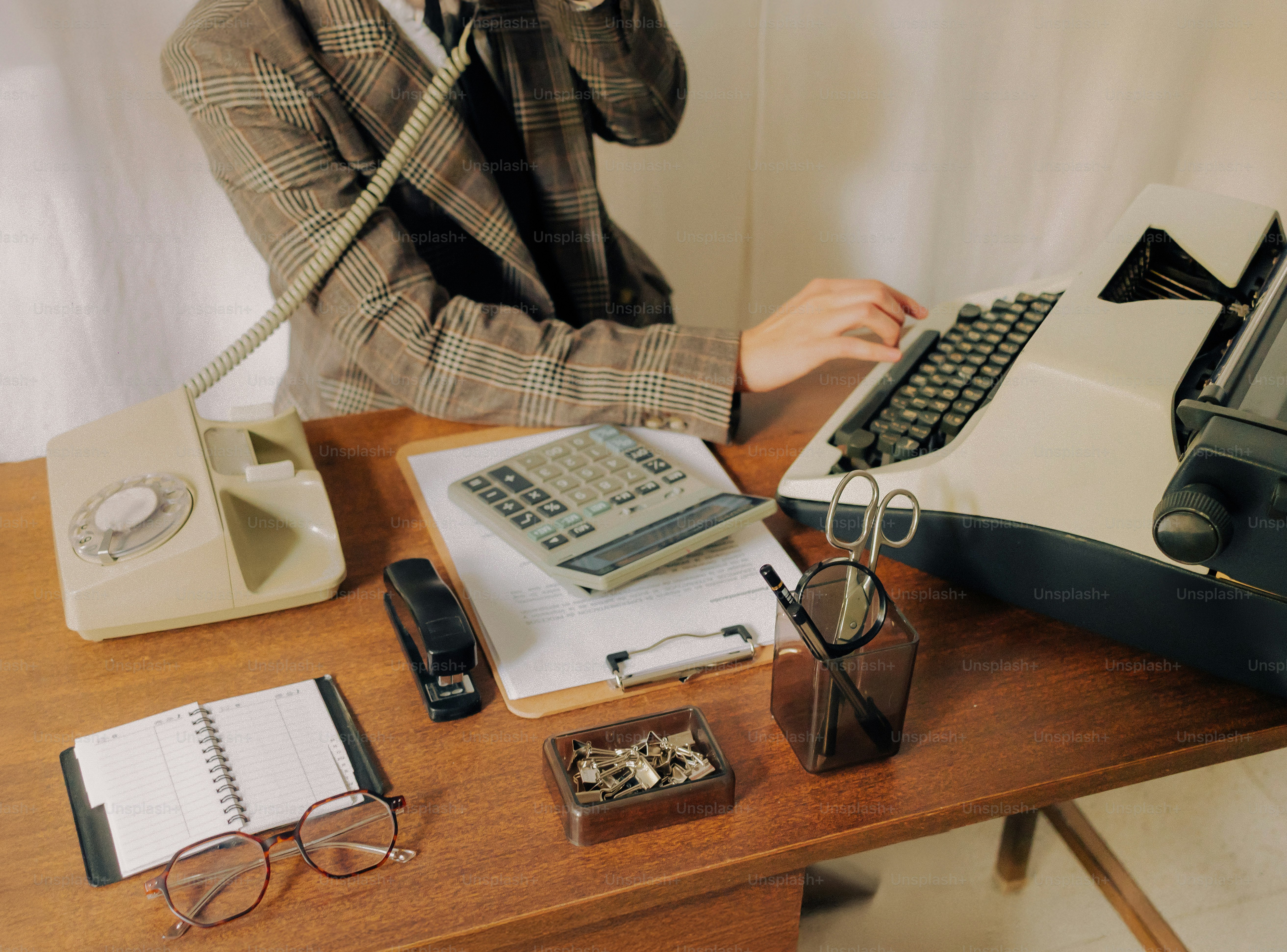 Person using a vintage typewriter and rotary phone. photo – Business ...