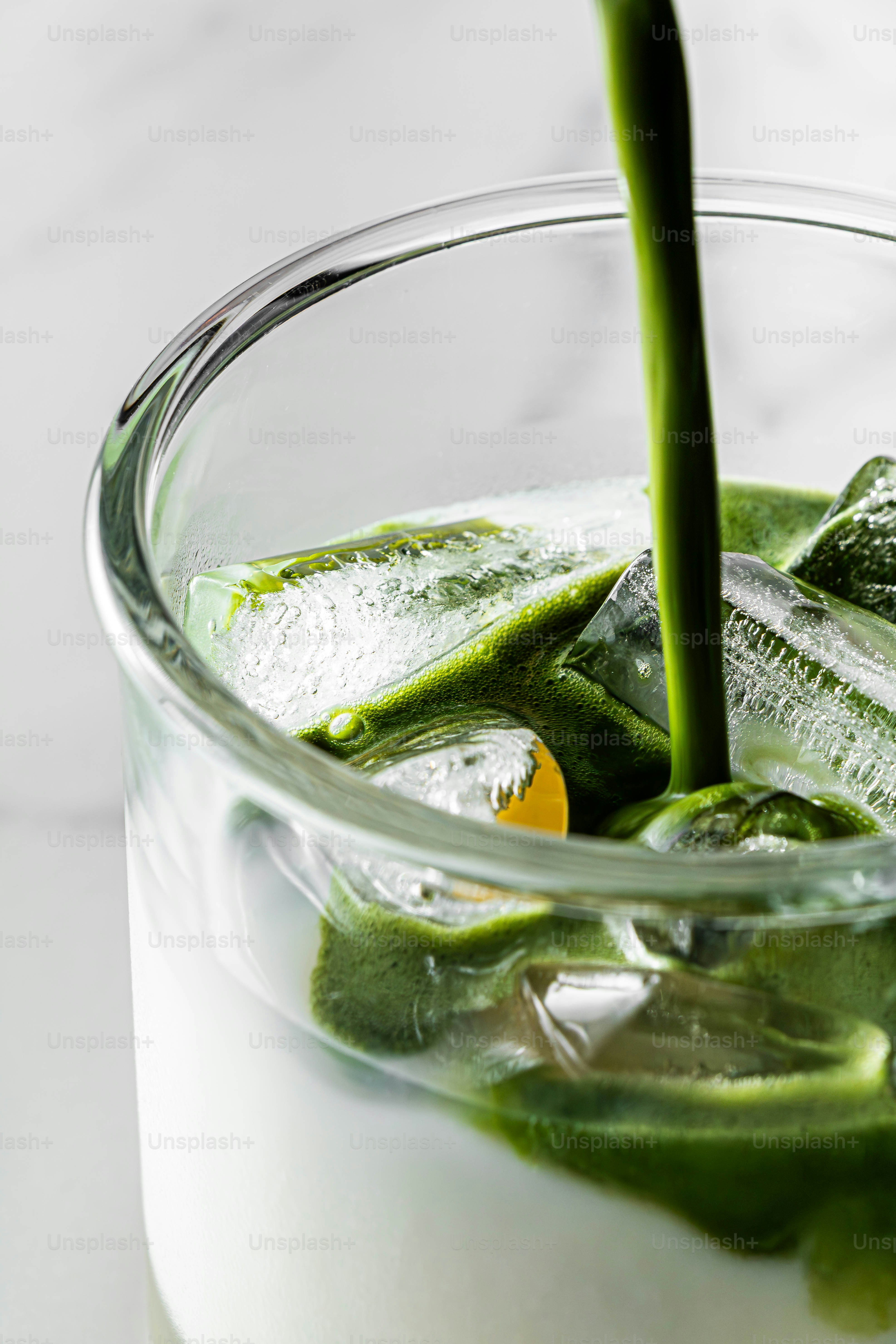 緑色の抹茶が牛乳のグラスに注がれる。