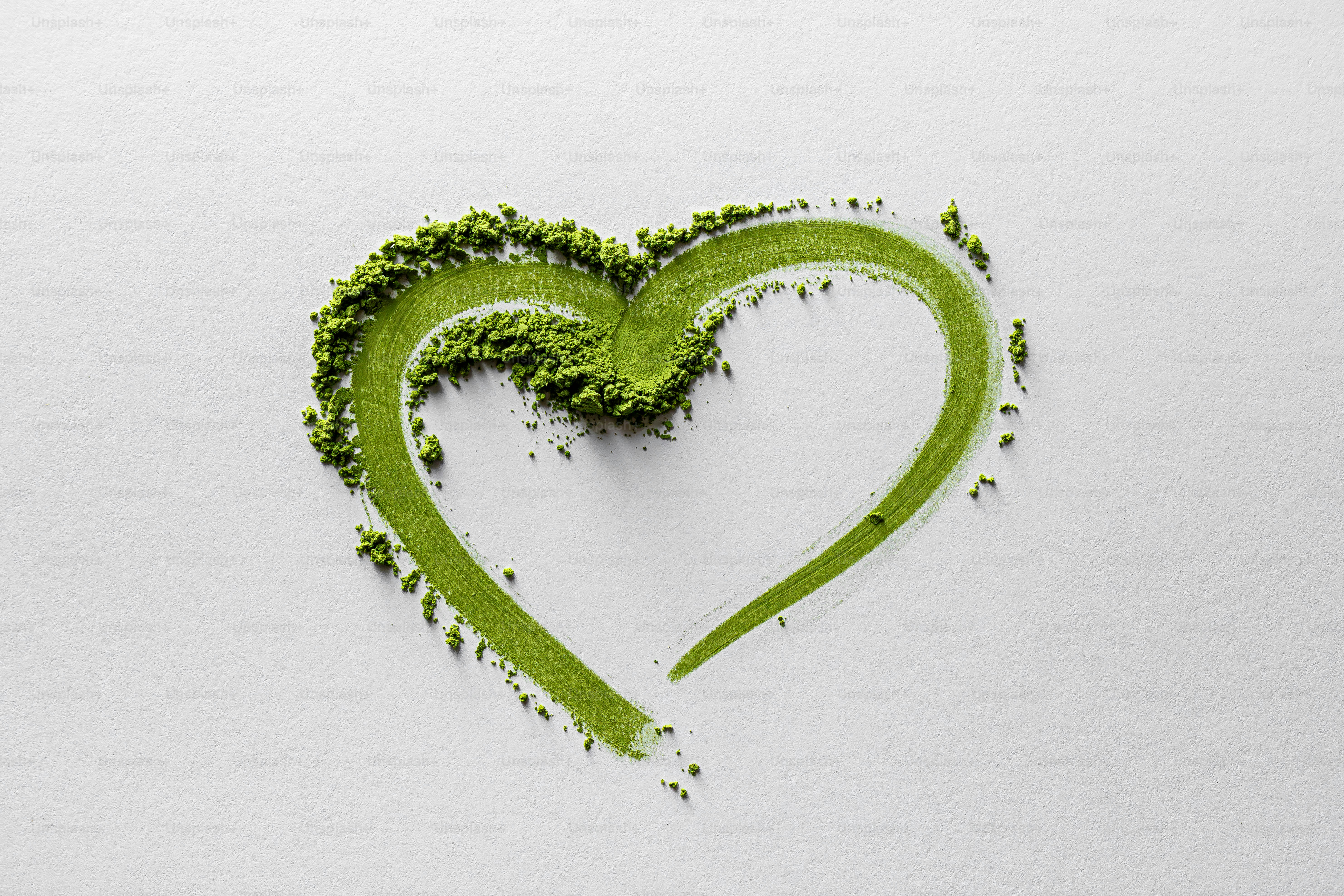 緑色の抹茶粉は白の上にハート型を形成します
