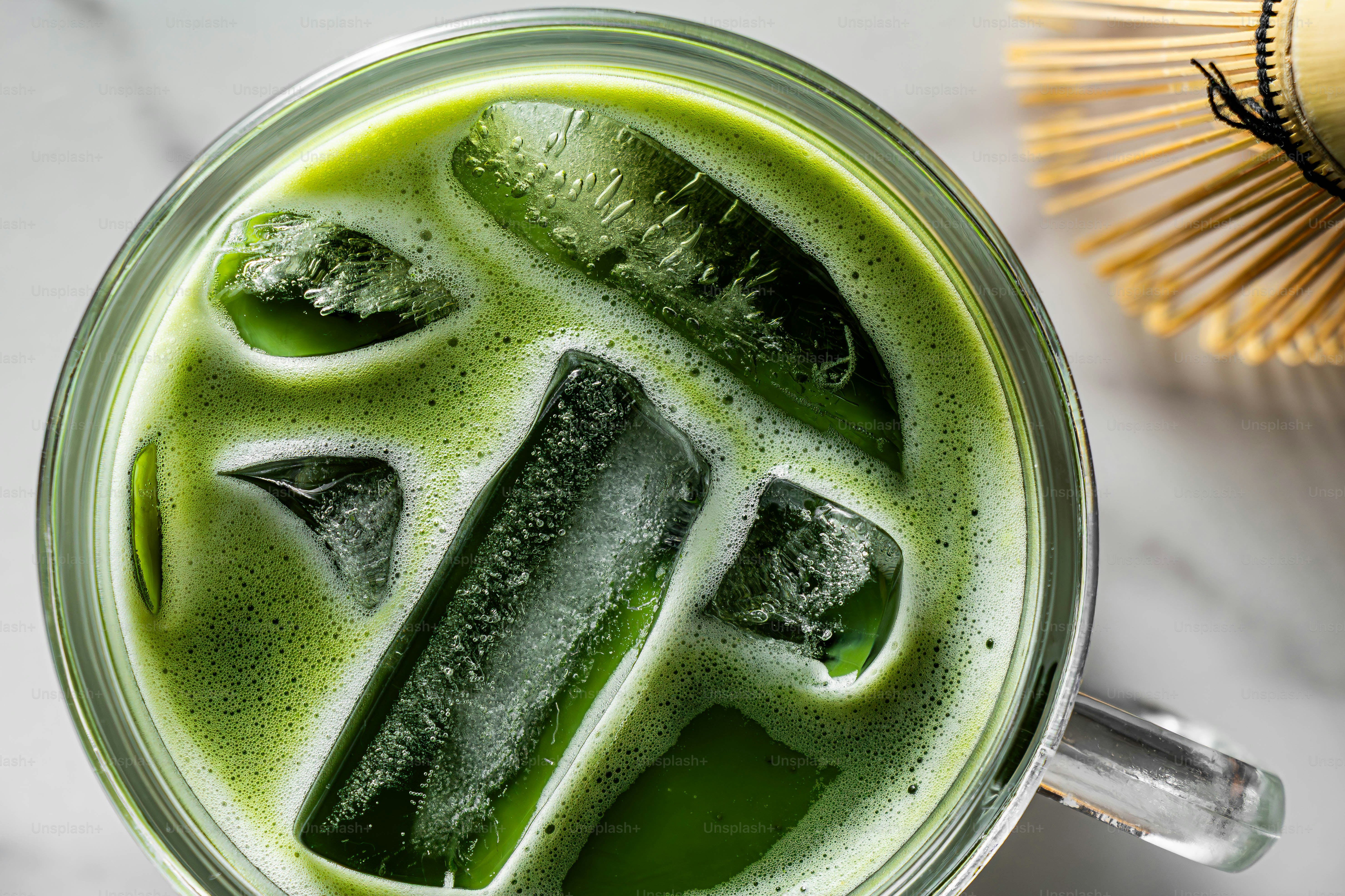 泡立つ泡と氷を添えたアイス抹茶ラテ。