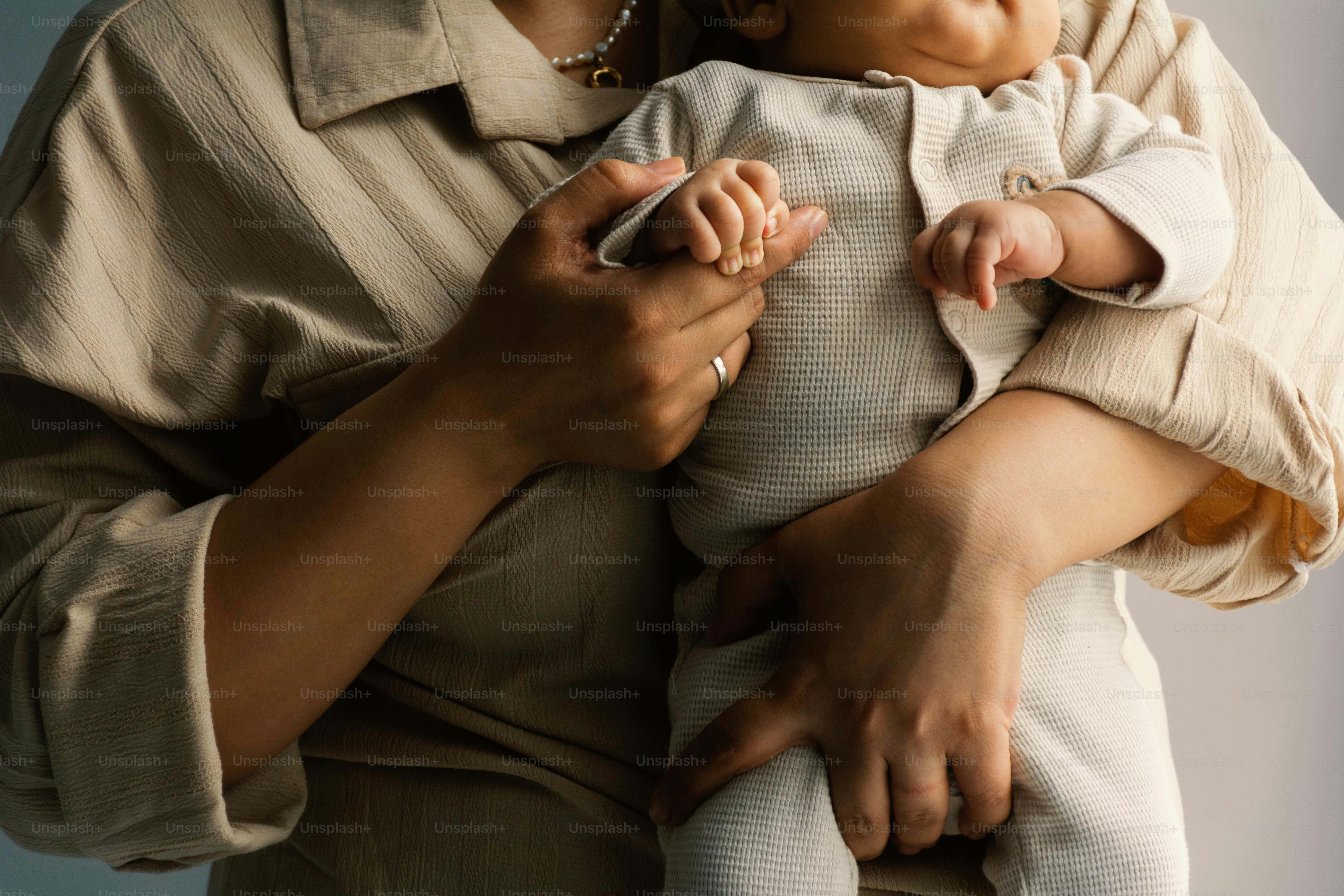 Una persona che tiene un bambino tra le braccia.