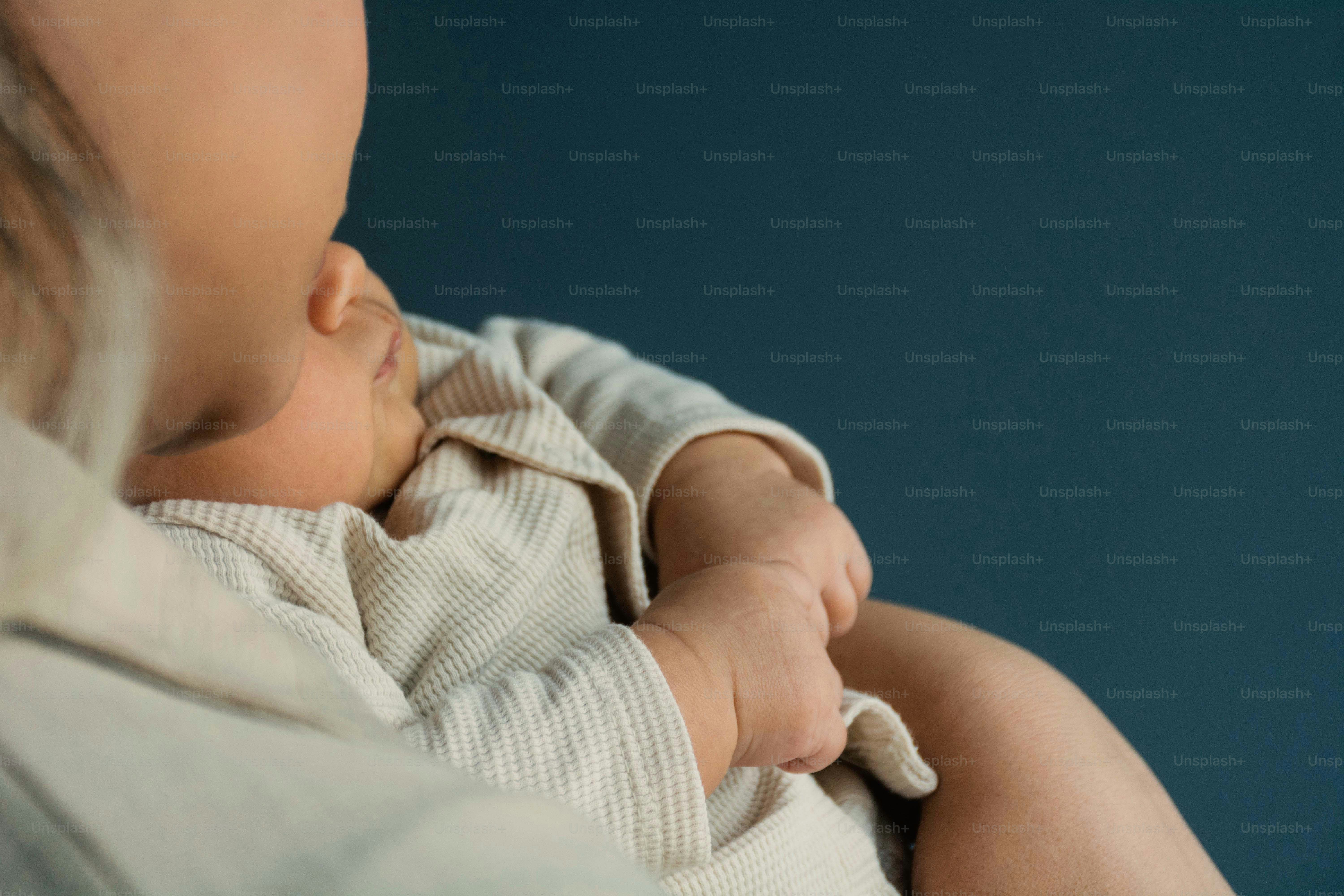 Genitore che tiene in braccio un neonato addormentato, da vicino neonato