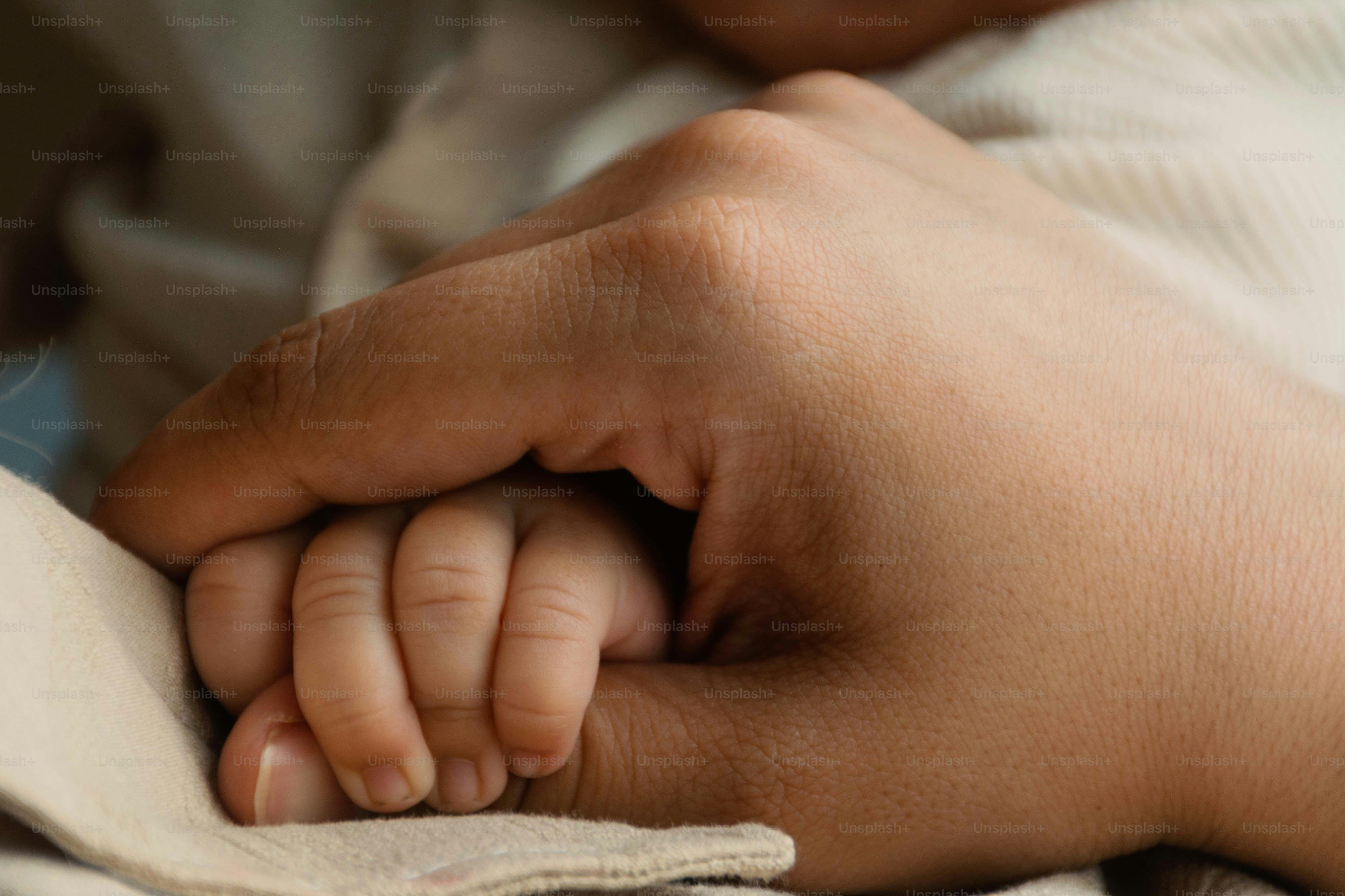 Mano adulta che tiene la piccola mano di un bambino