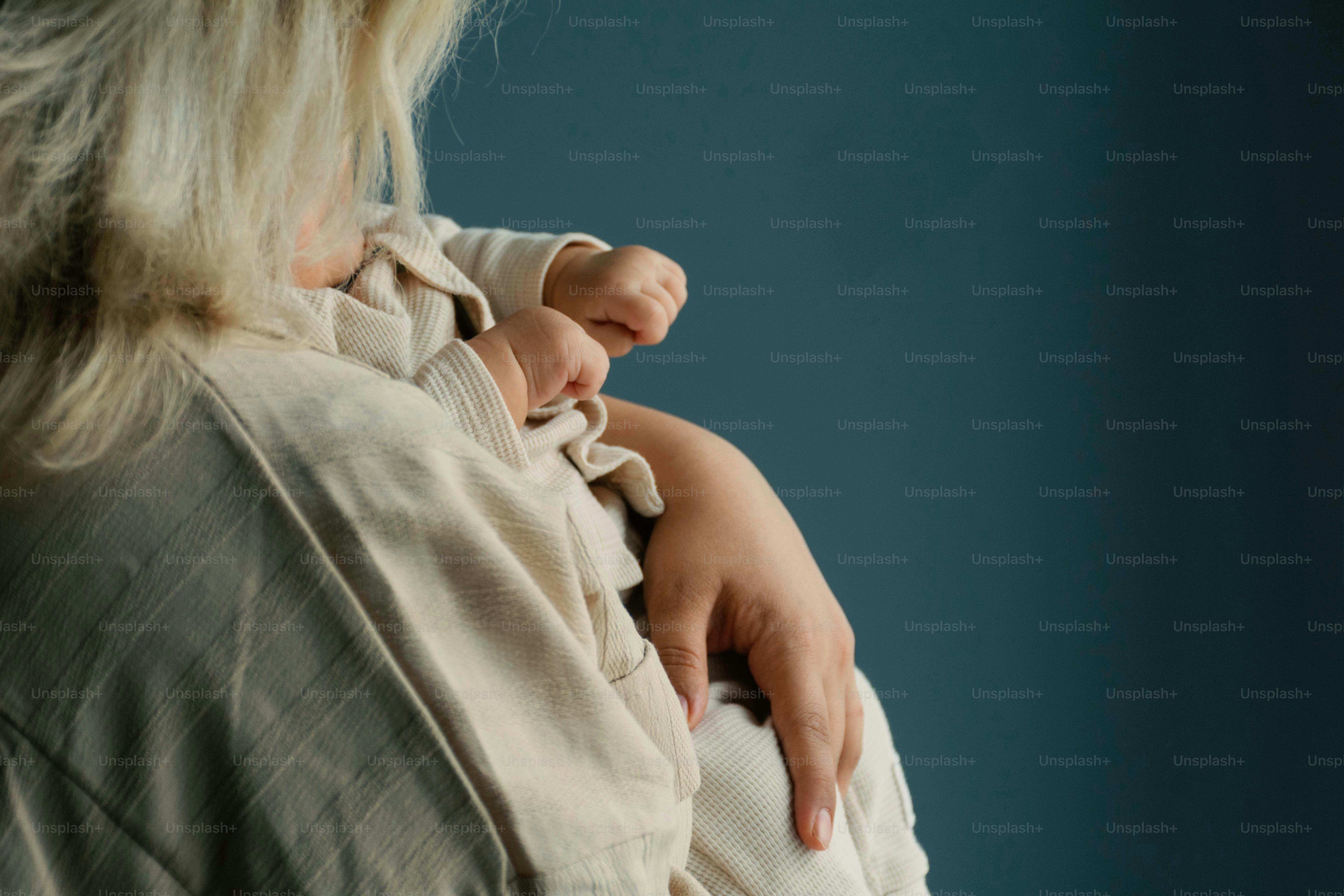 Madre che tiene un bambino addormentato sulla spalla