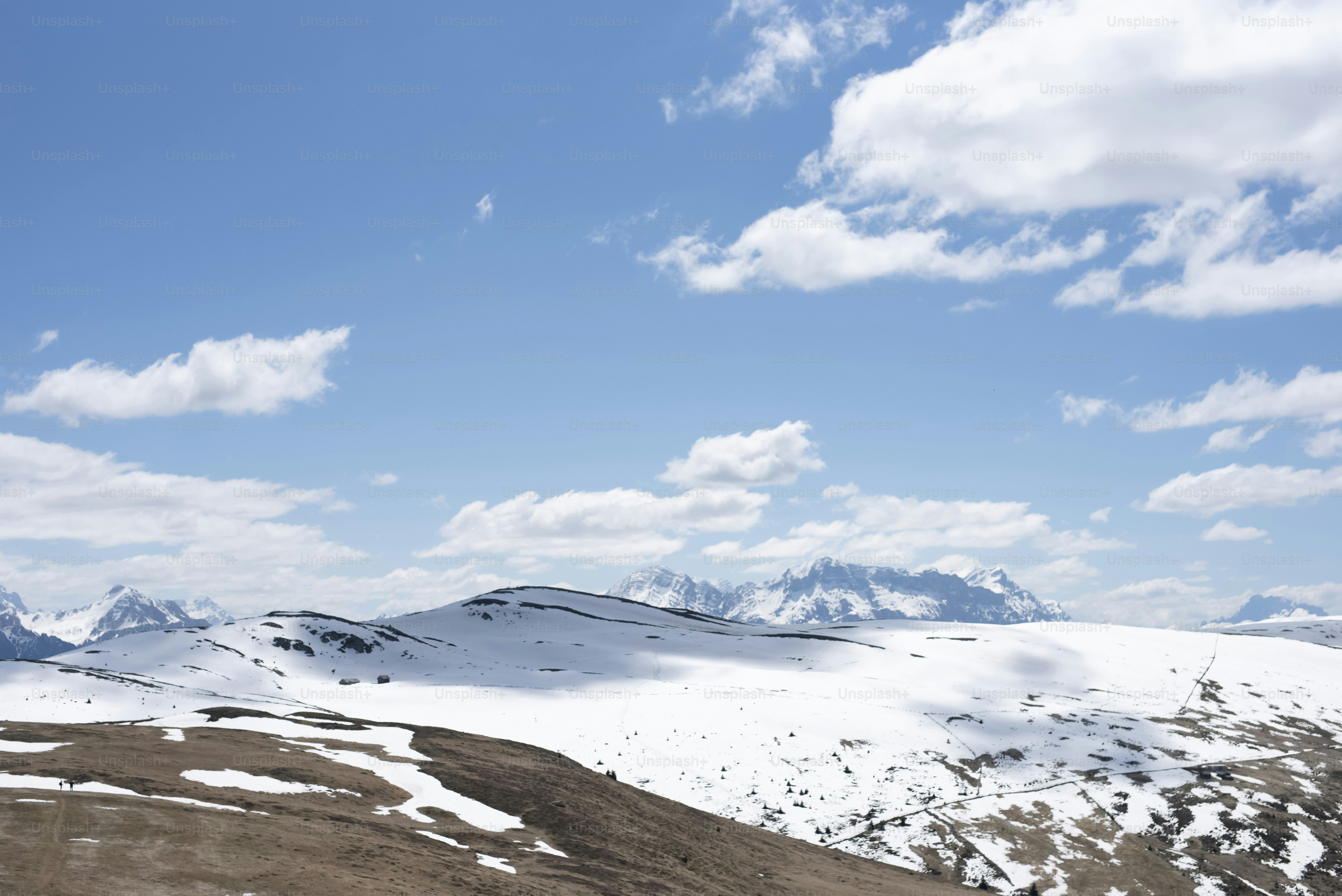 눈 덮인 산들, 밝은 푸른 하늘 아래