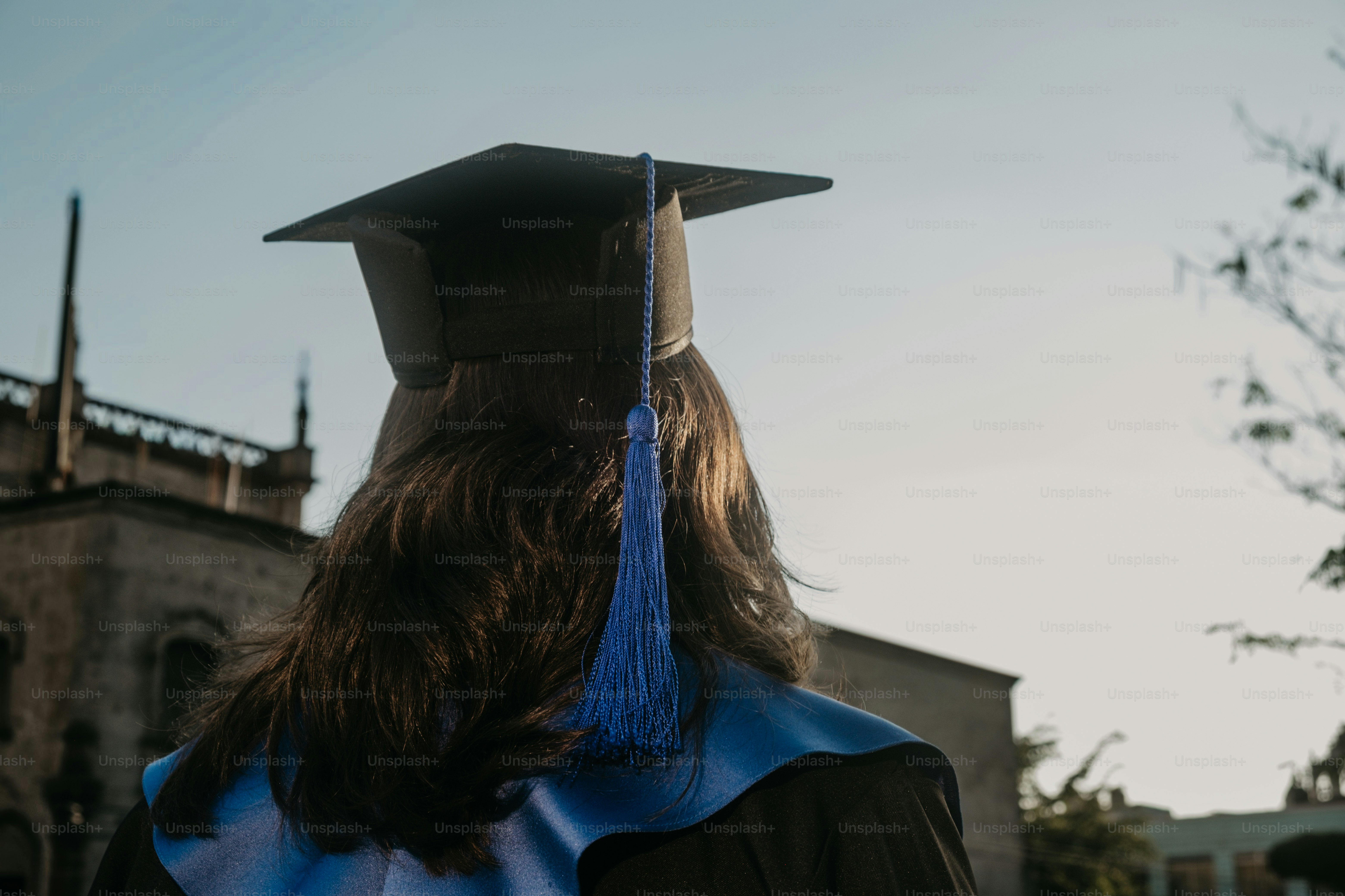 Graduate in cap and gown facing away from camera photo – Education ...