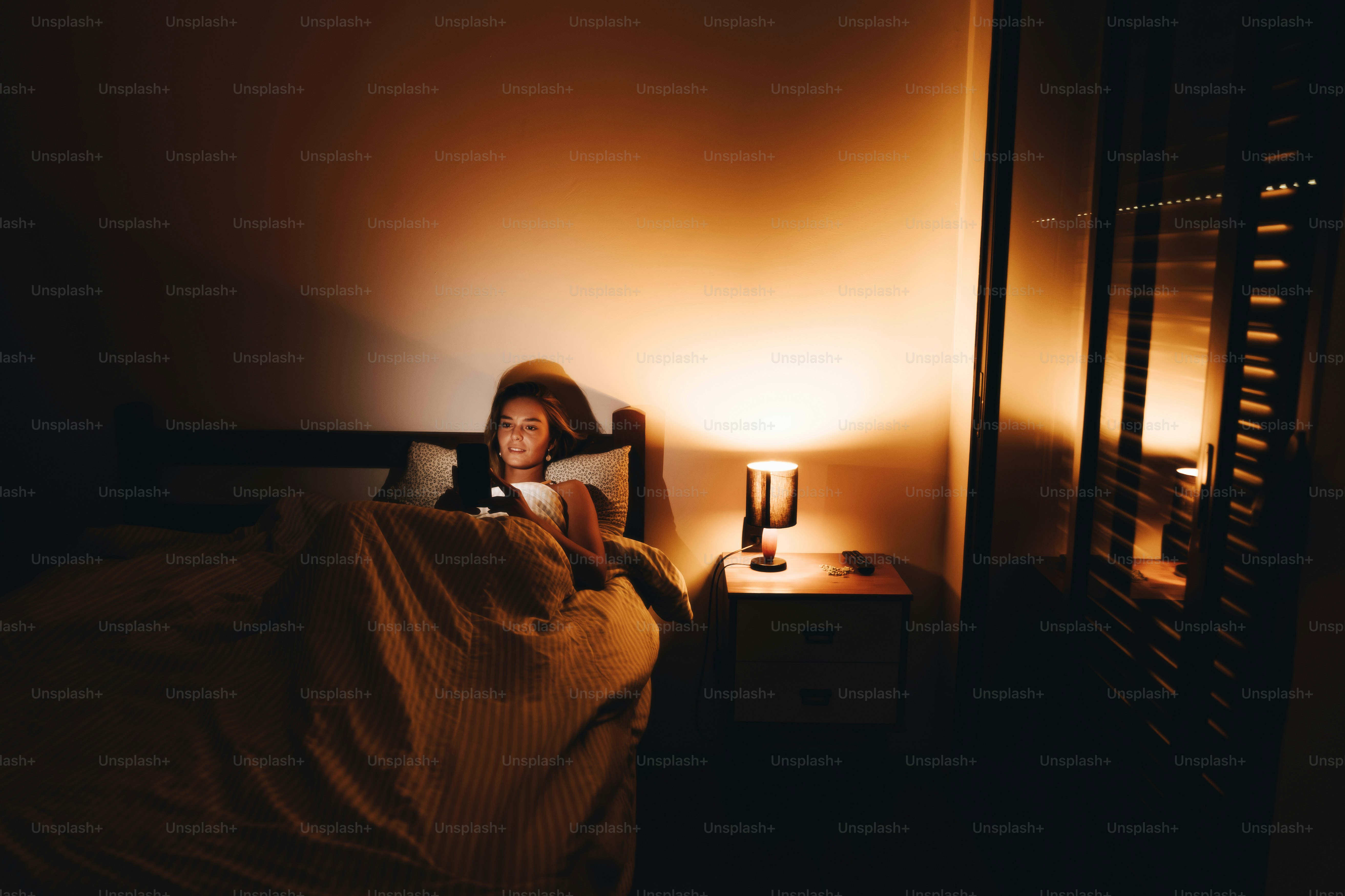 Una persona usa una tableta en la cama por la noche.