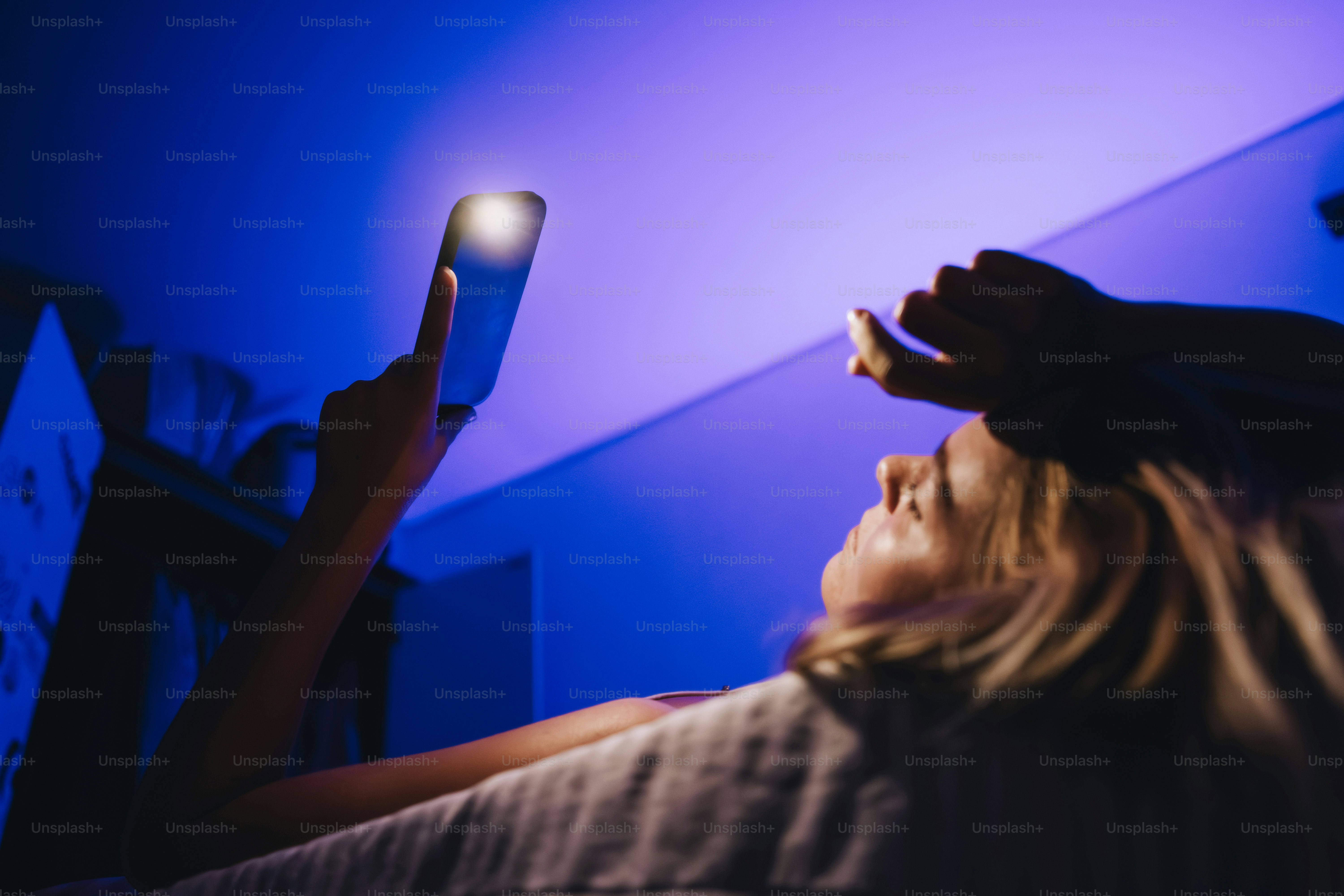 Mujer mirando el móvil en una habitación oscura