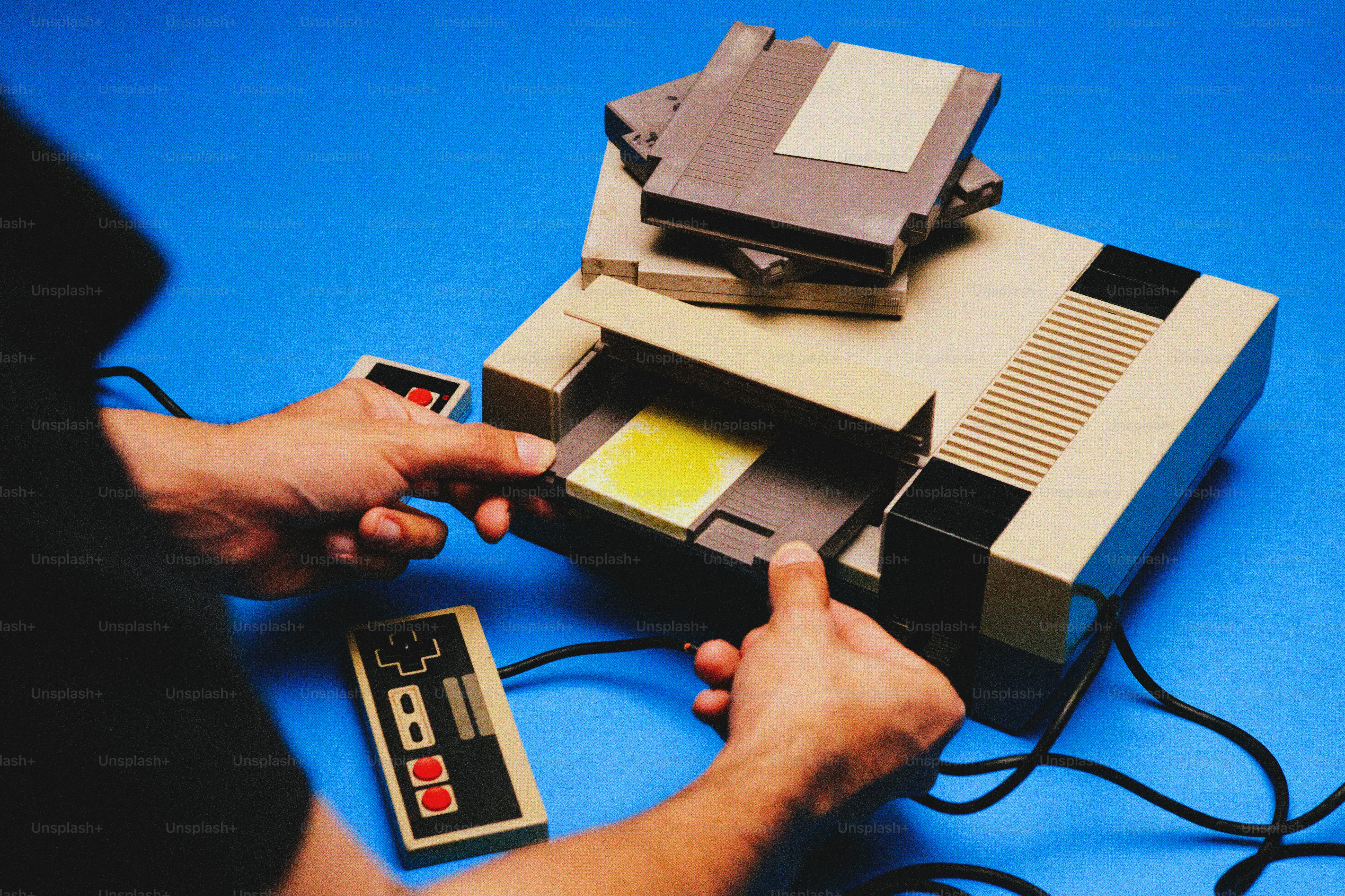 Mains insérant une cartouche dans une console de jeux vintage