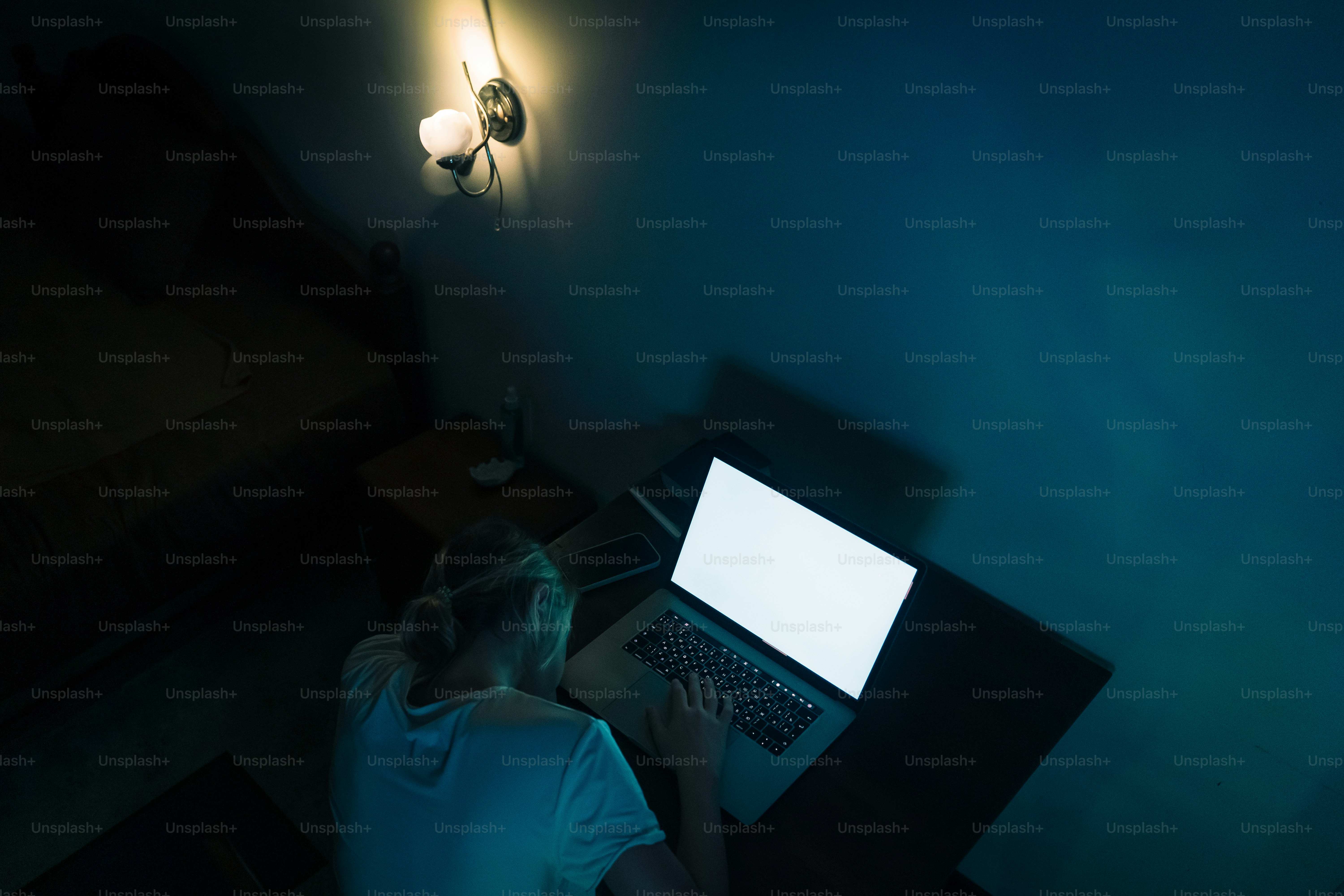Orang yang bekerja di laptop di ruangan gelap.