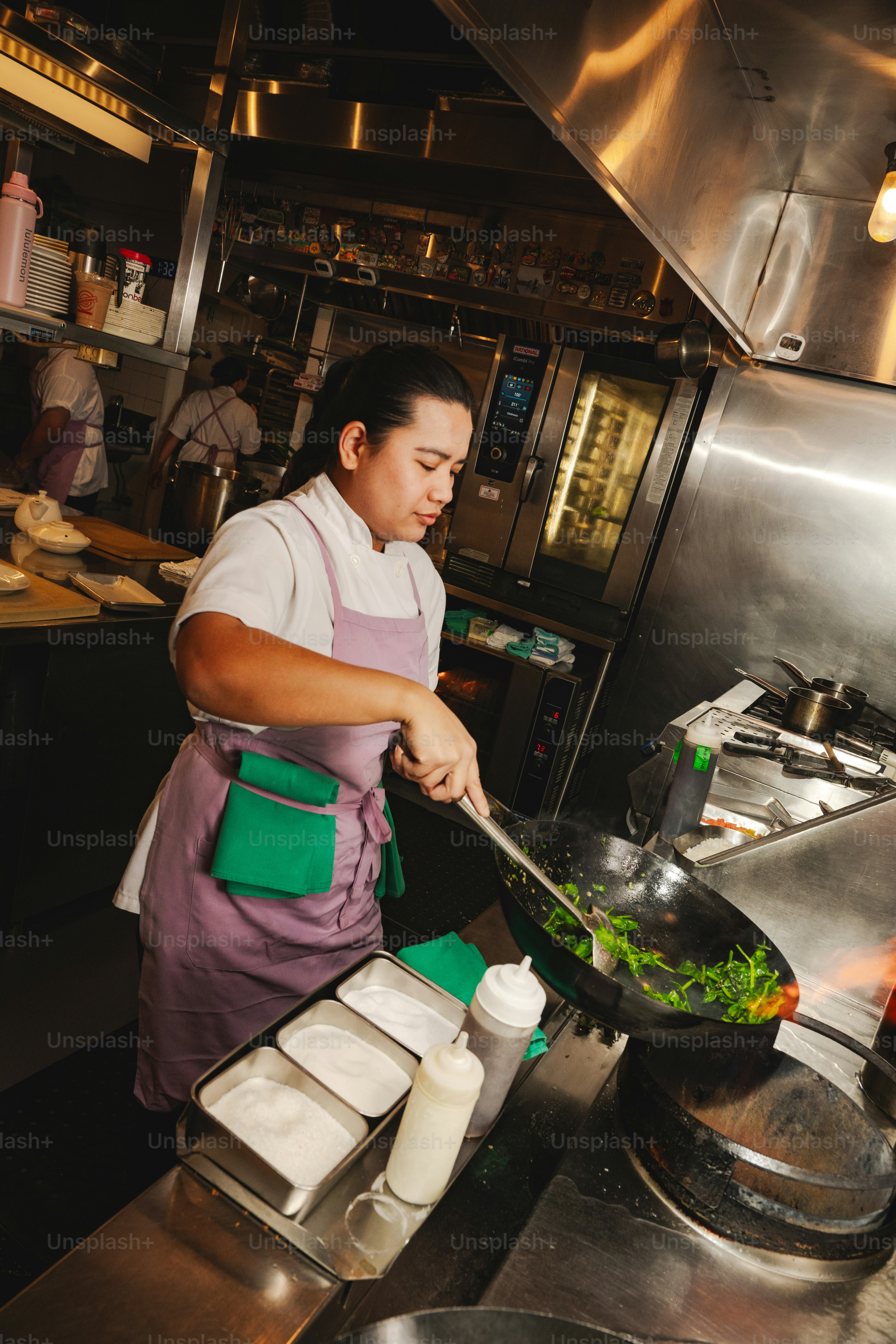 A chef cooking vegetables in a wok