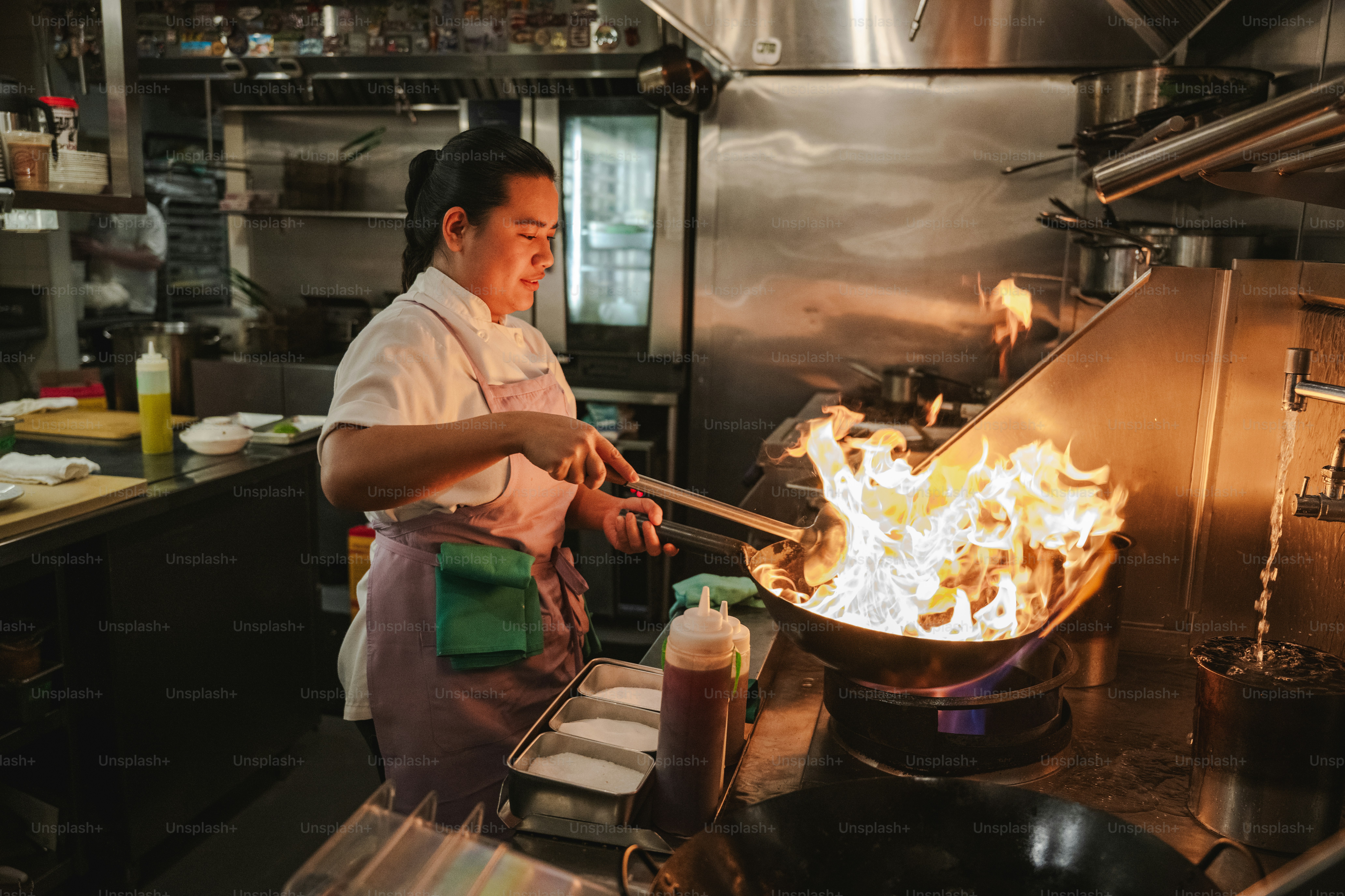 中華鍋で炎を使って料理をしているシェフ