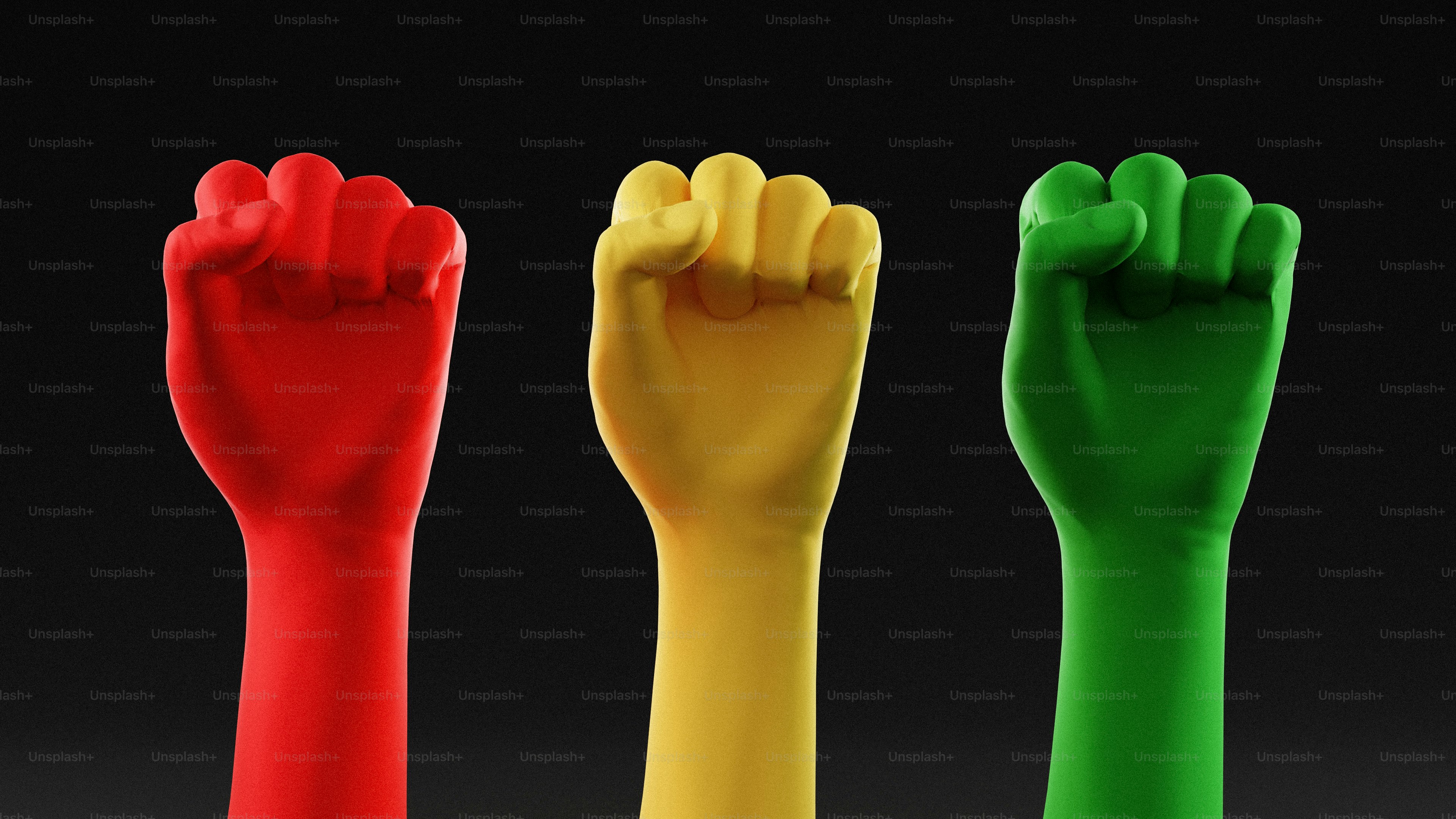 Trois poings levés en rouge, jaune et vert.