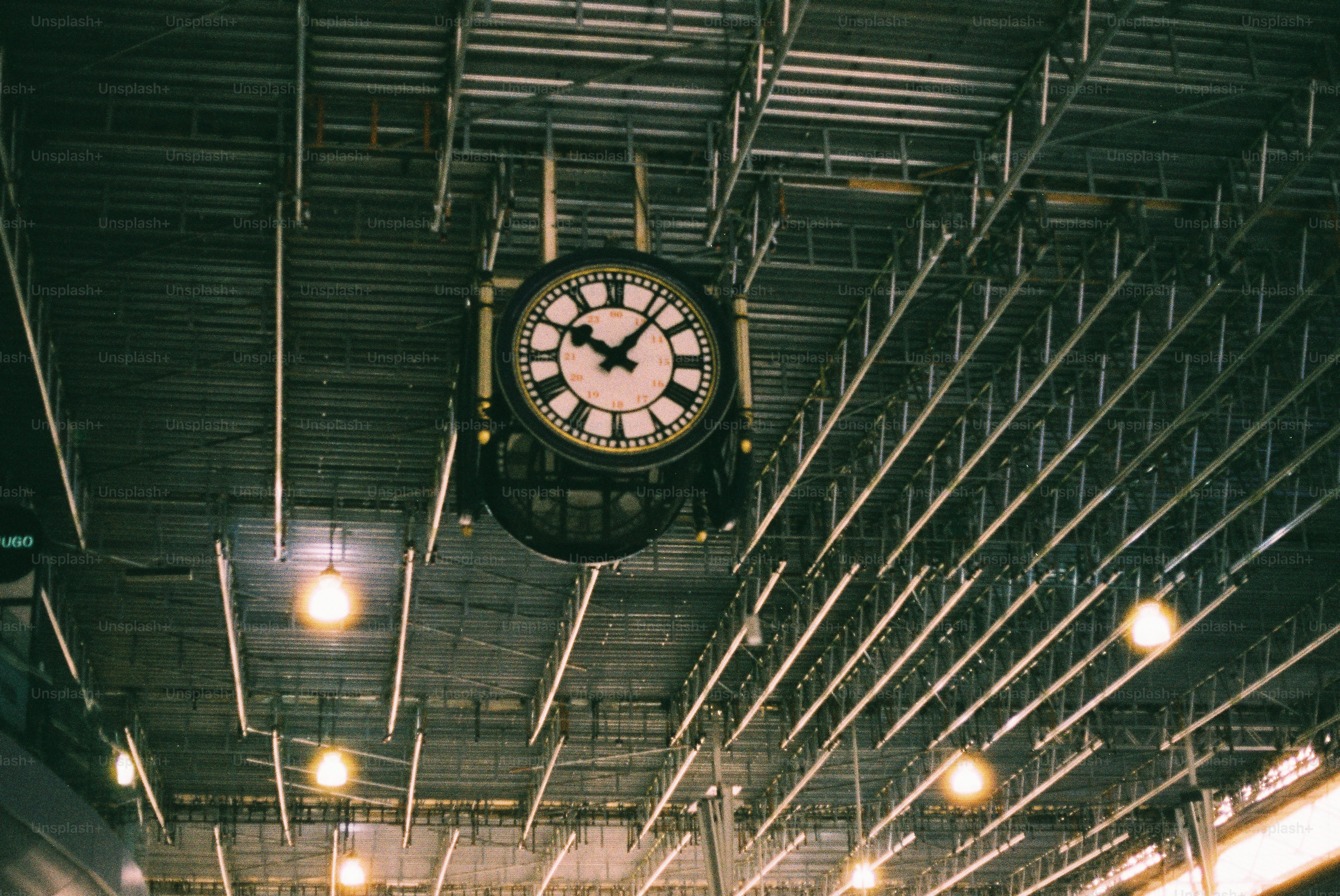 A large clock hangs from a ceiling photo – Travel Image on Unsplash