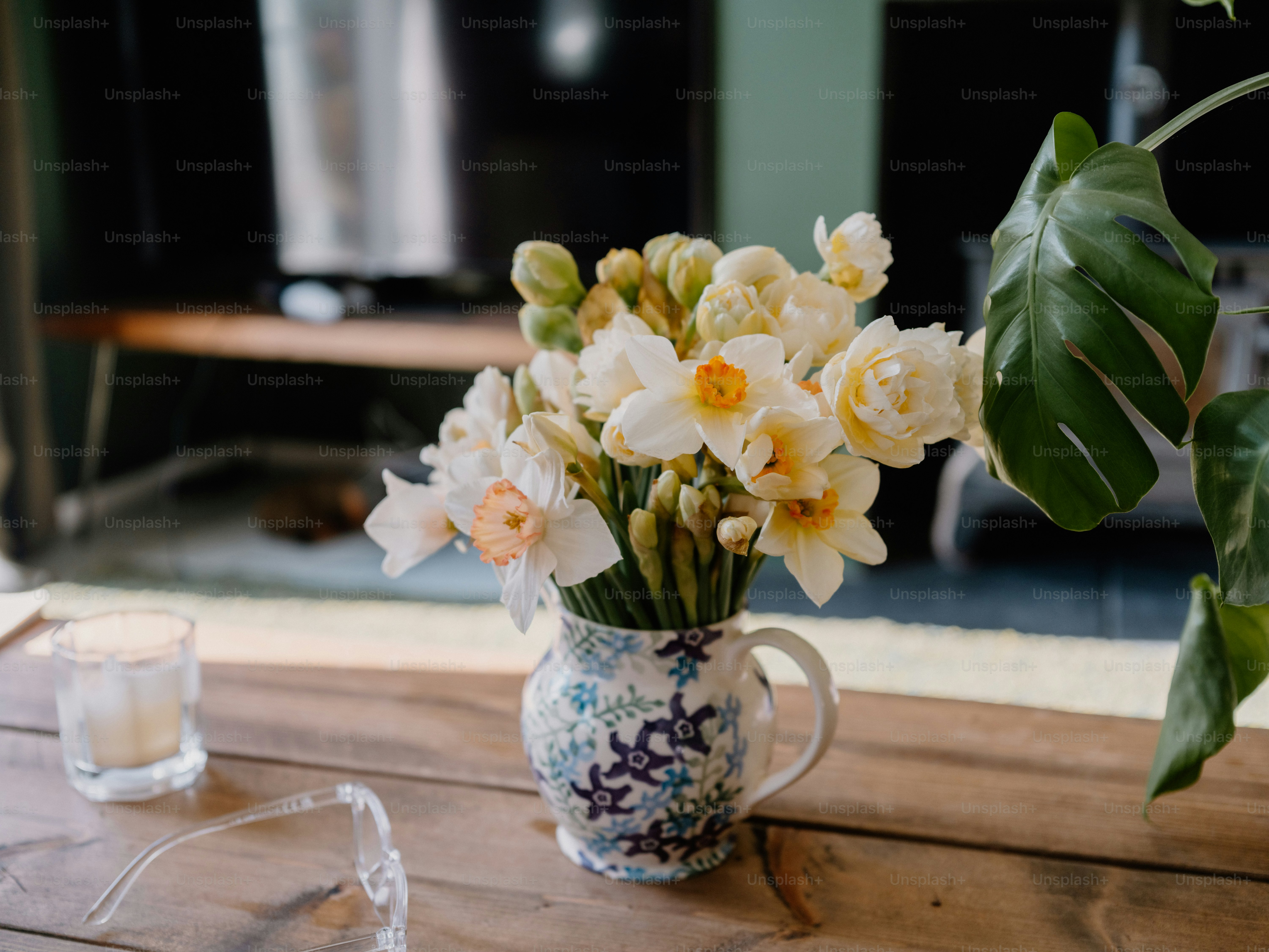 A bouquet of daffodils in a decorative pitcher.