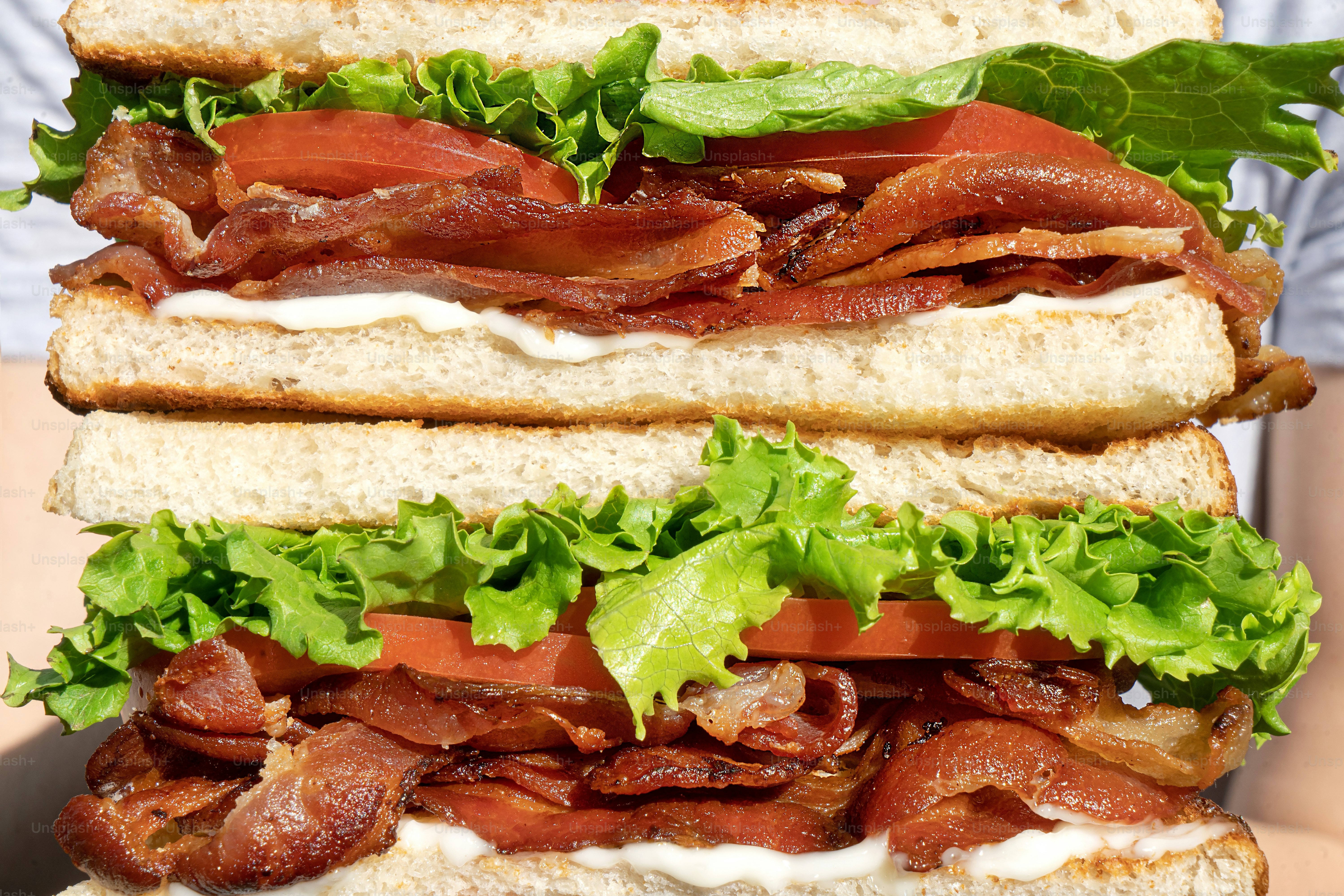 A tall club sandwich with bacon, lettuce, and tomato