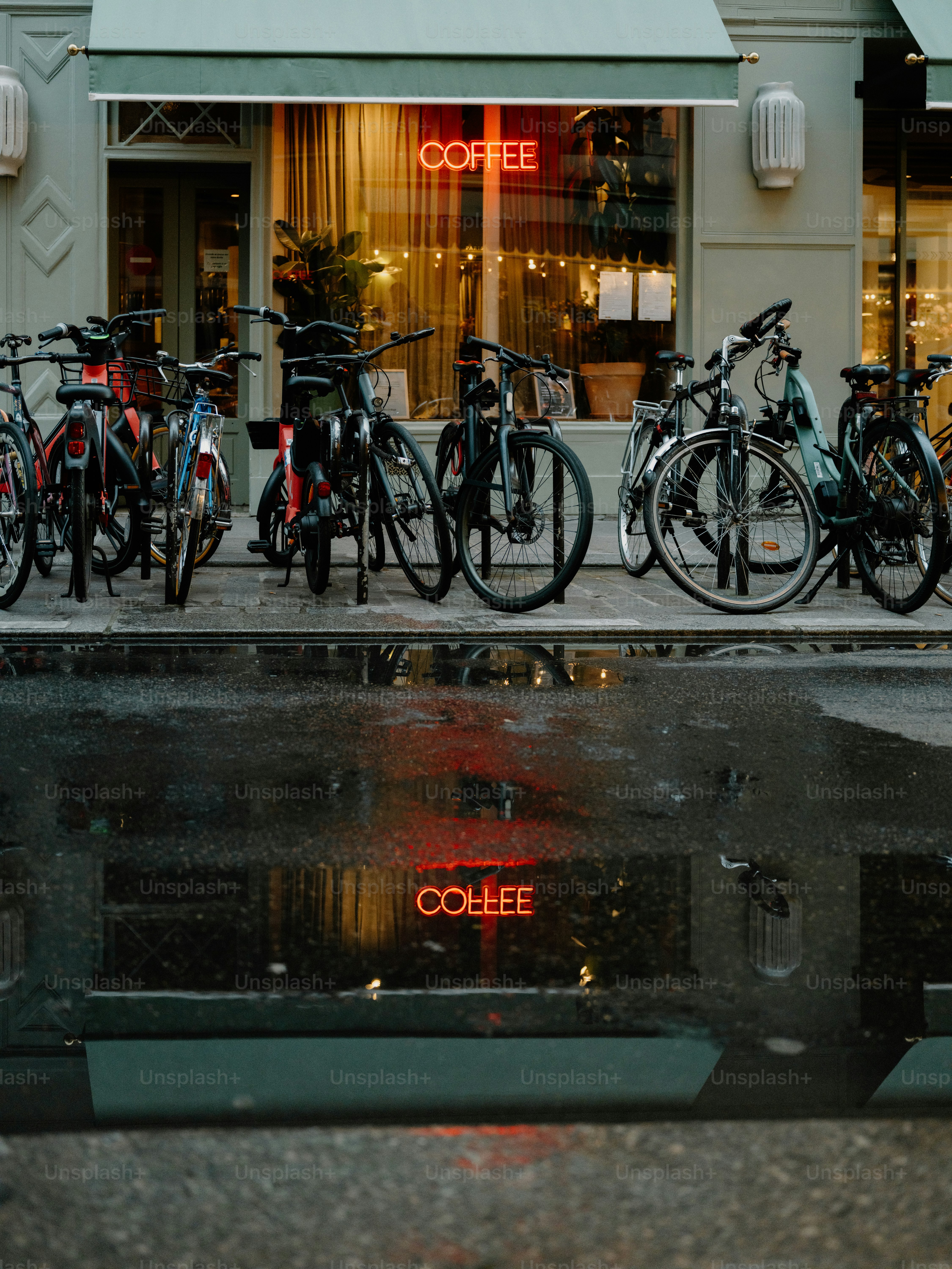 Fahrräder vor einem Café mit einem Neonschild geparkt