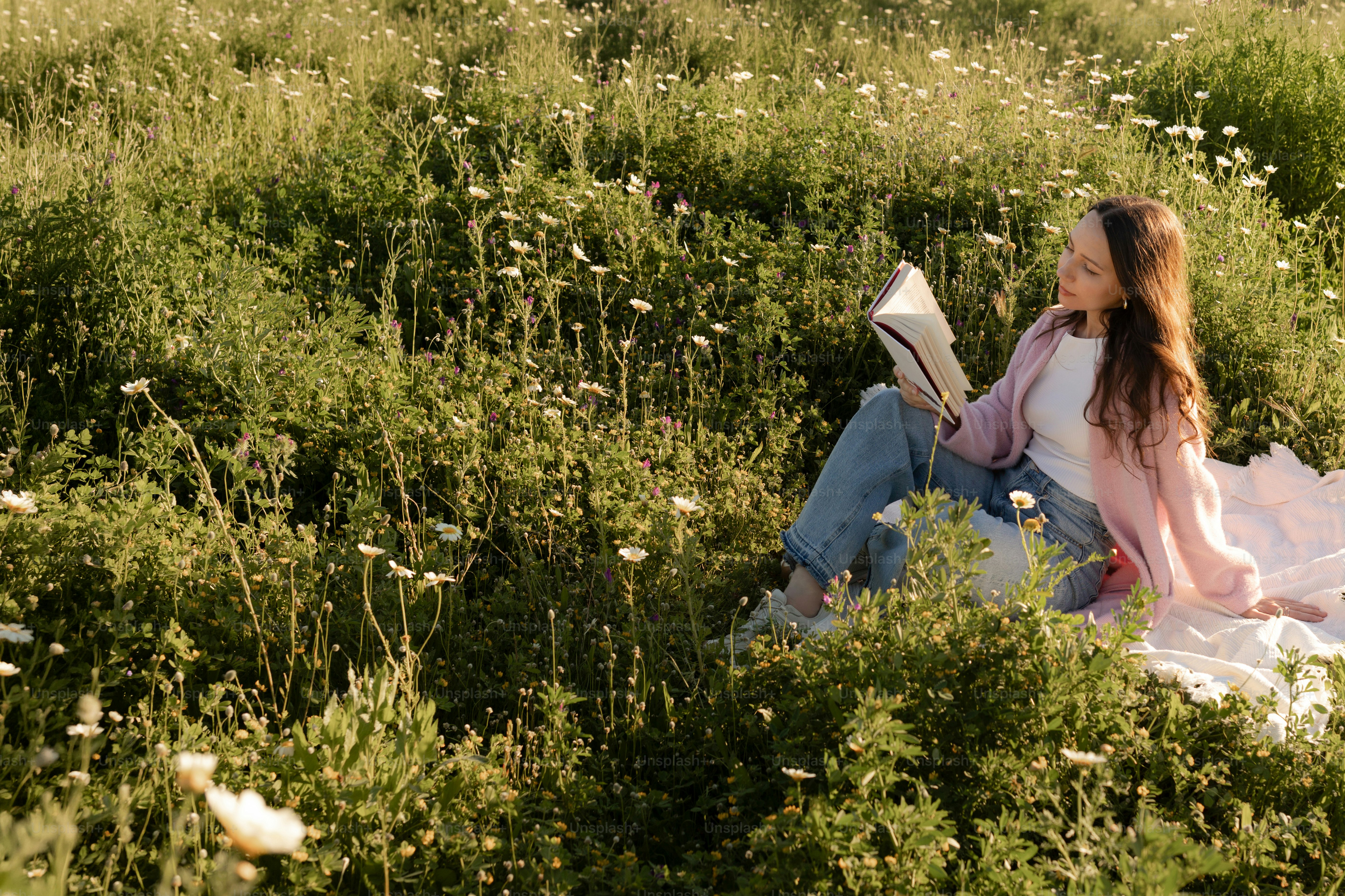 Femme lisant un livre dans un champ de fleurs