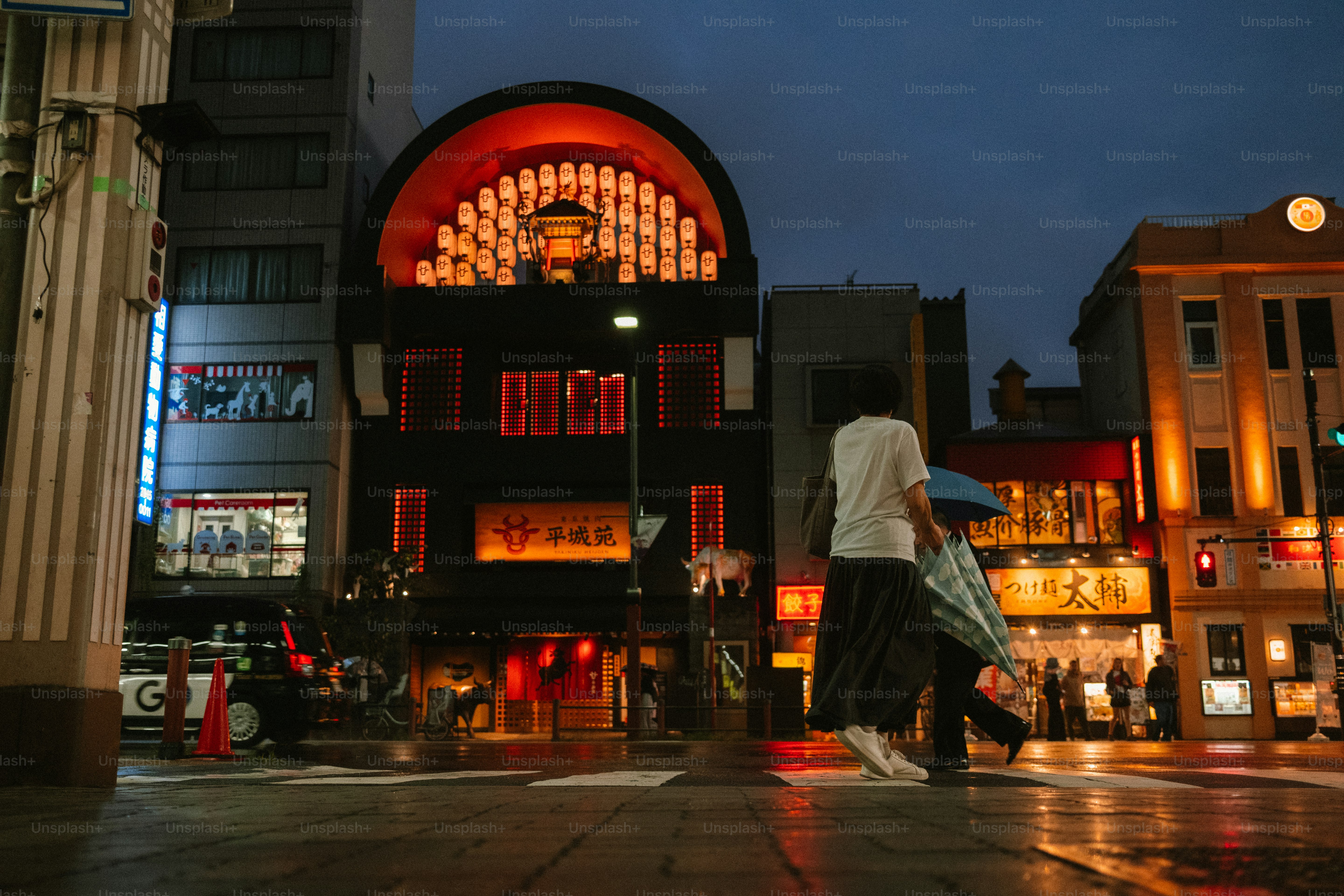 Pemandangan jalanan saat senja dengan bangunan yang diterangi.