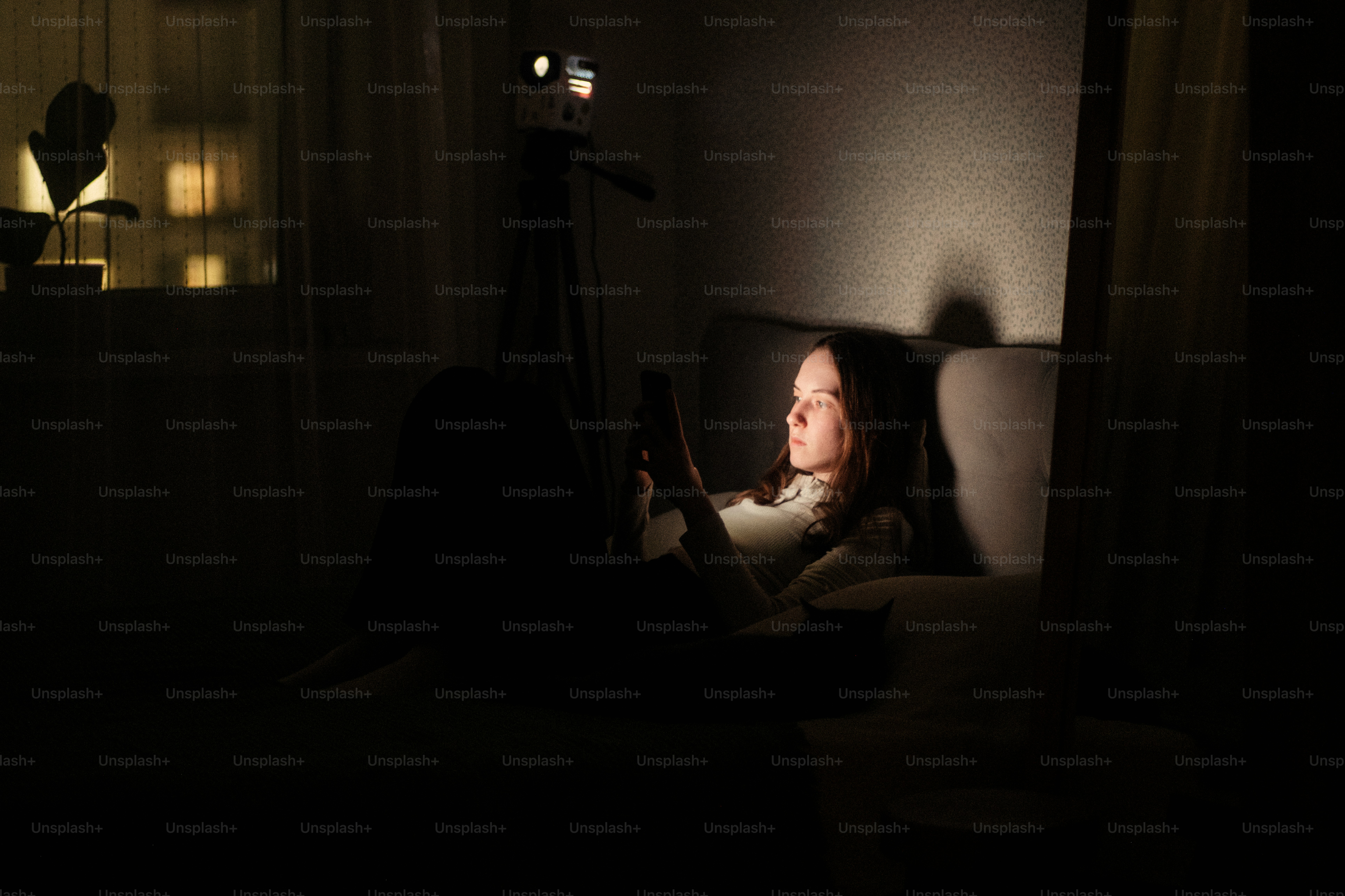 Frau von einer Tafel im dunklen Raum beleuchtet